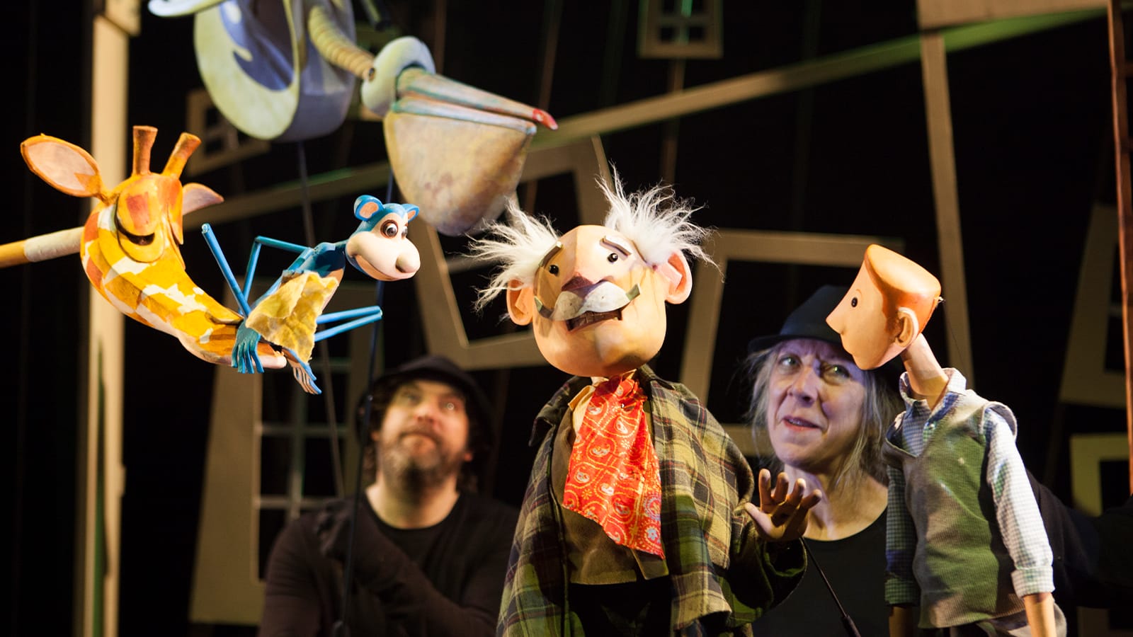 A wooden puppet of an old man, a giraffe and a monkey from the show the giraffe, the pelly and me