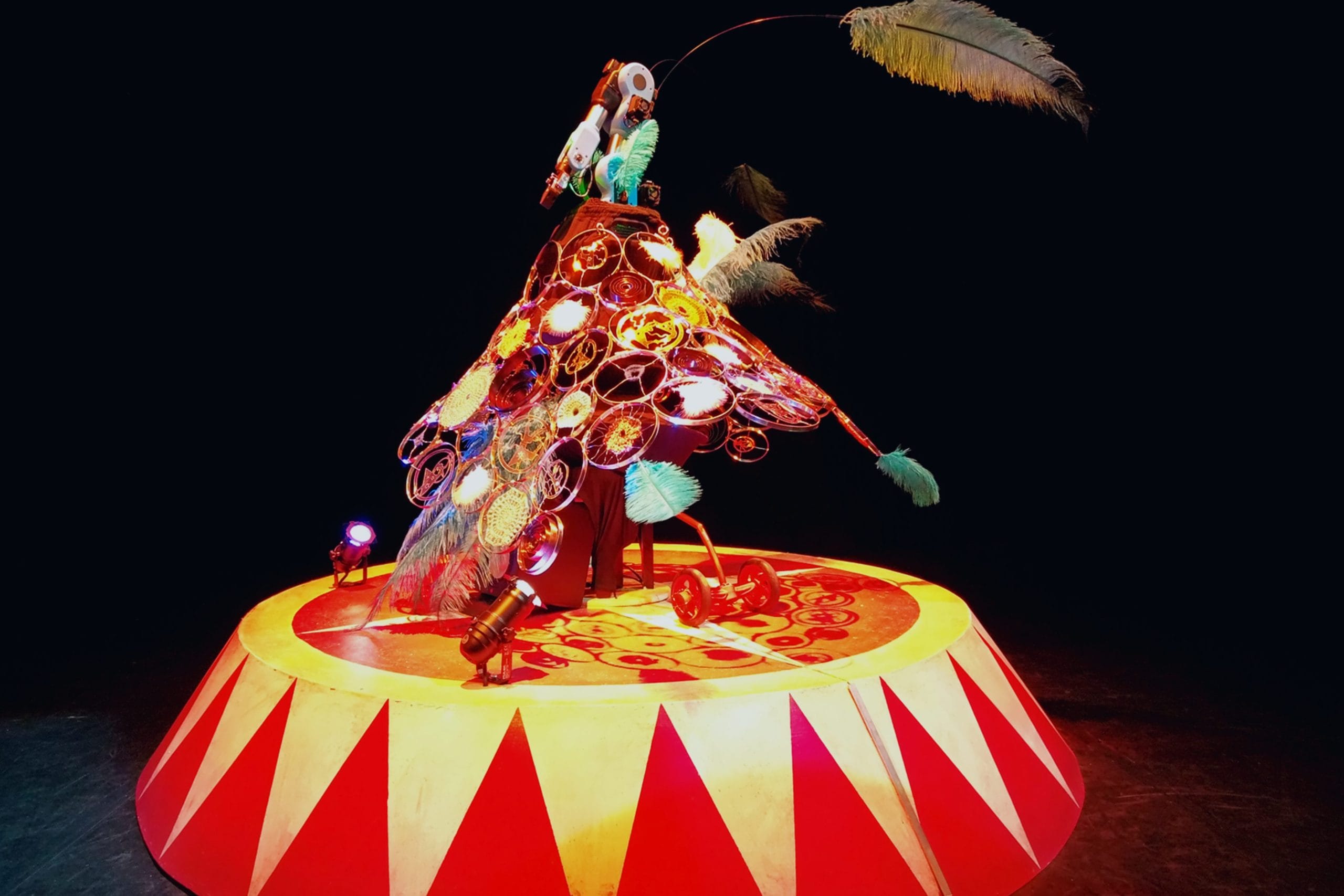 A red and yellow circus tent style stand with a spinning feather contraption