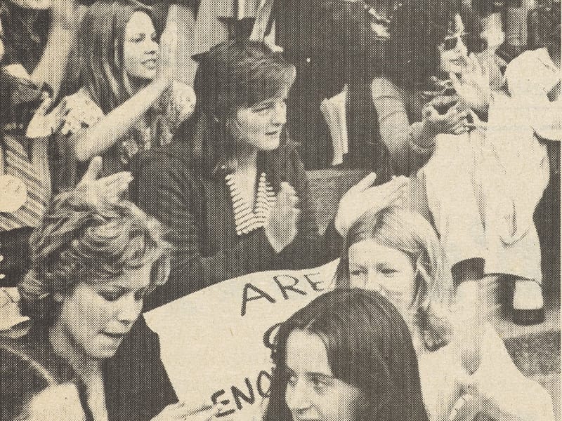 A black and white photograph of women holding up protest signs.