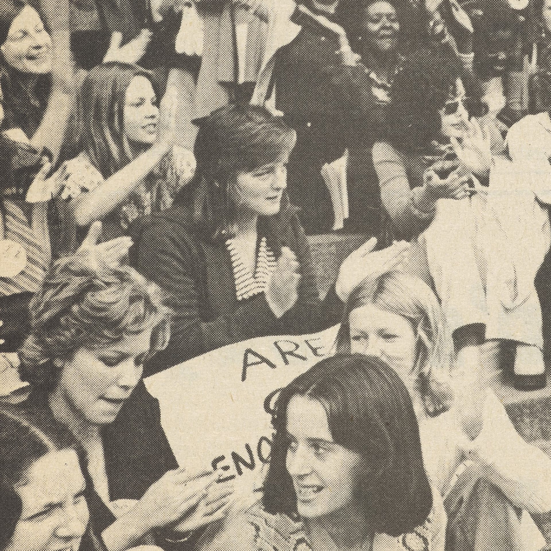 A black and white photo of a group of women holding protest signs