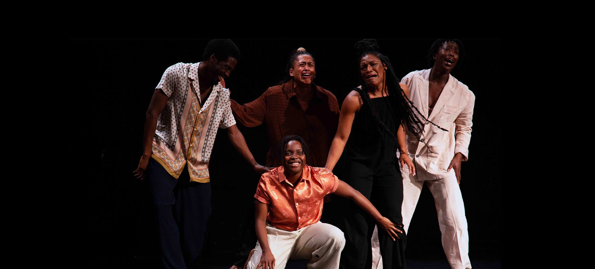 A group of dancers on stage showing a range of emotions