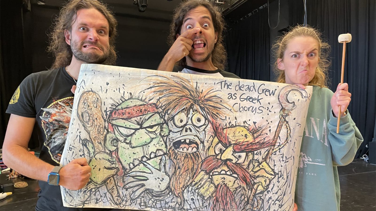 Three performers hold up an image of pirates