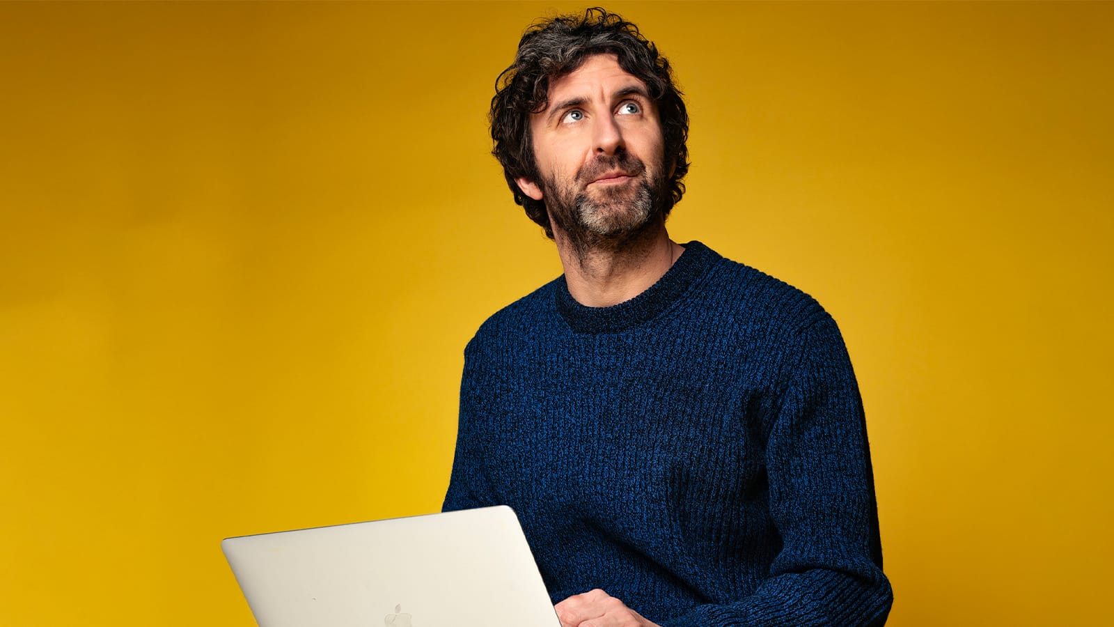 Mark Watson sits with a laptop