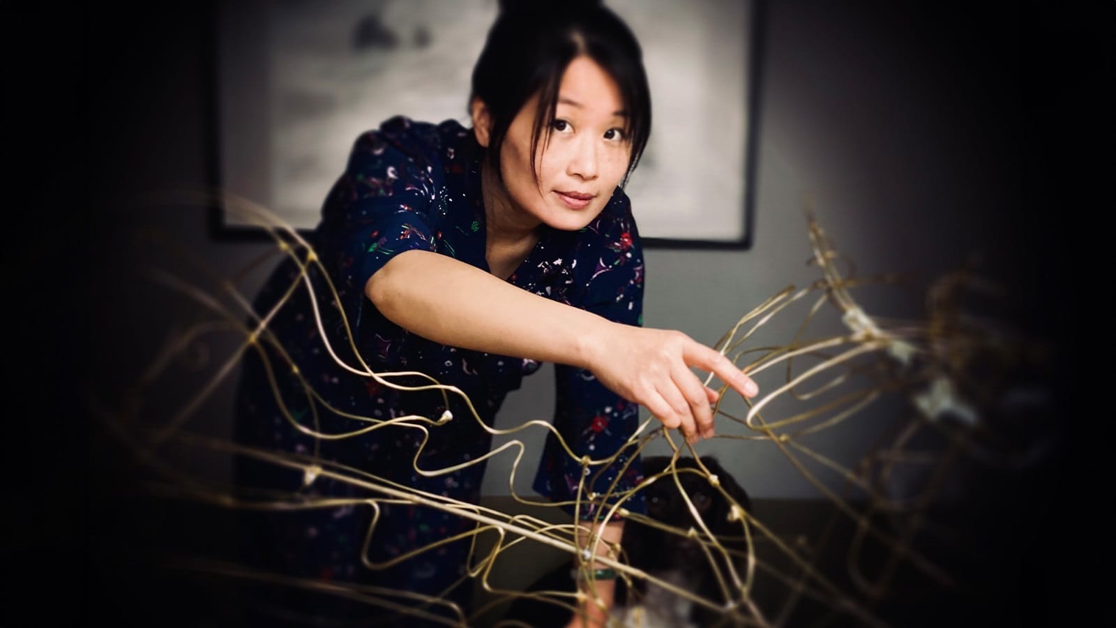 A woman using wire to craft a dragon