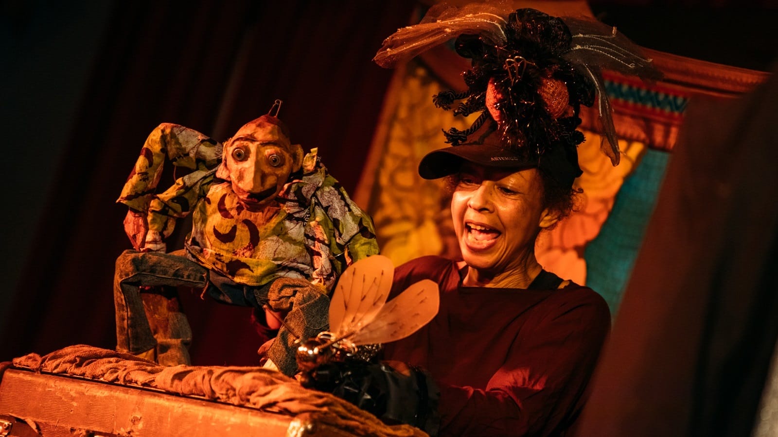 A woman operates a large spider puppet