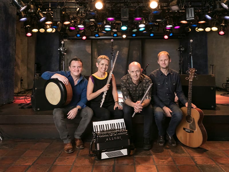 Four musicians from Flook hold up their instruments