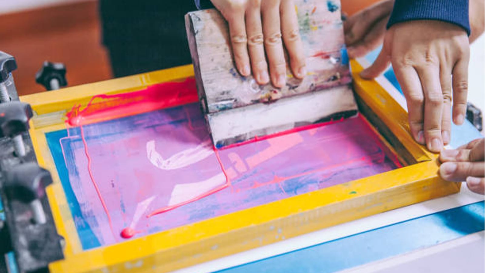 Hands making a print with a print press device