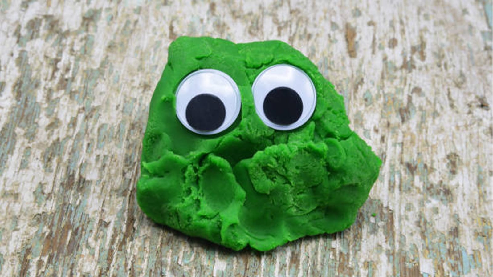A blob of green clay with googly eyes