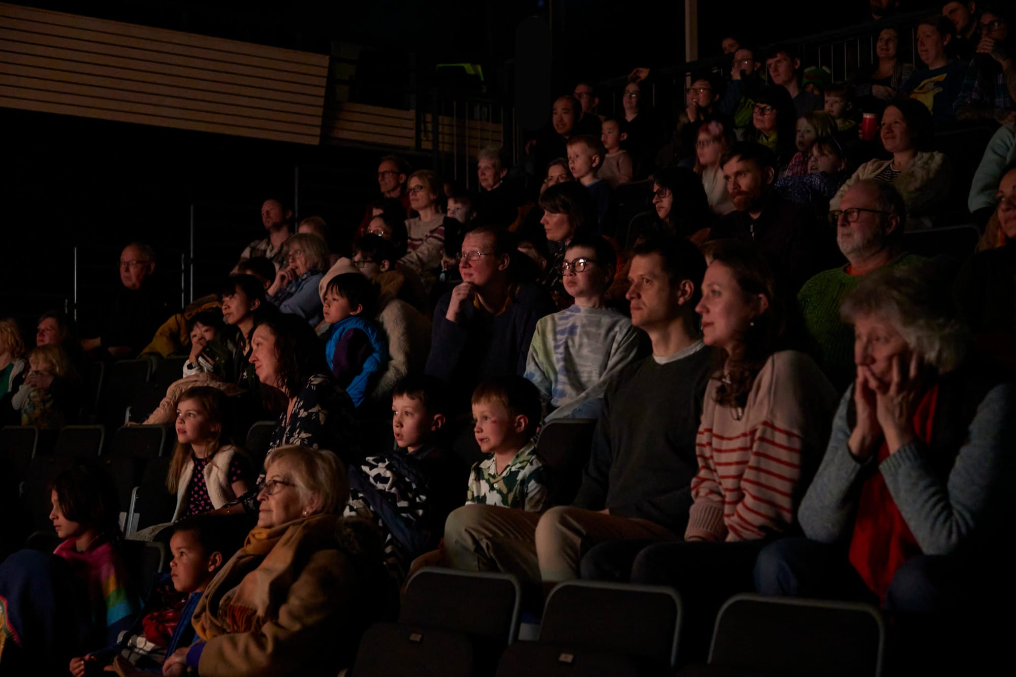 Rows of parents, grandparents and children sitting in Lakeside's dark theatre, their faces illuminated by what is taking place on stage.