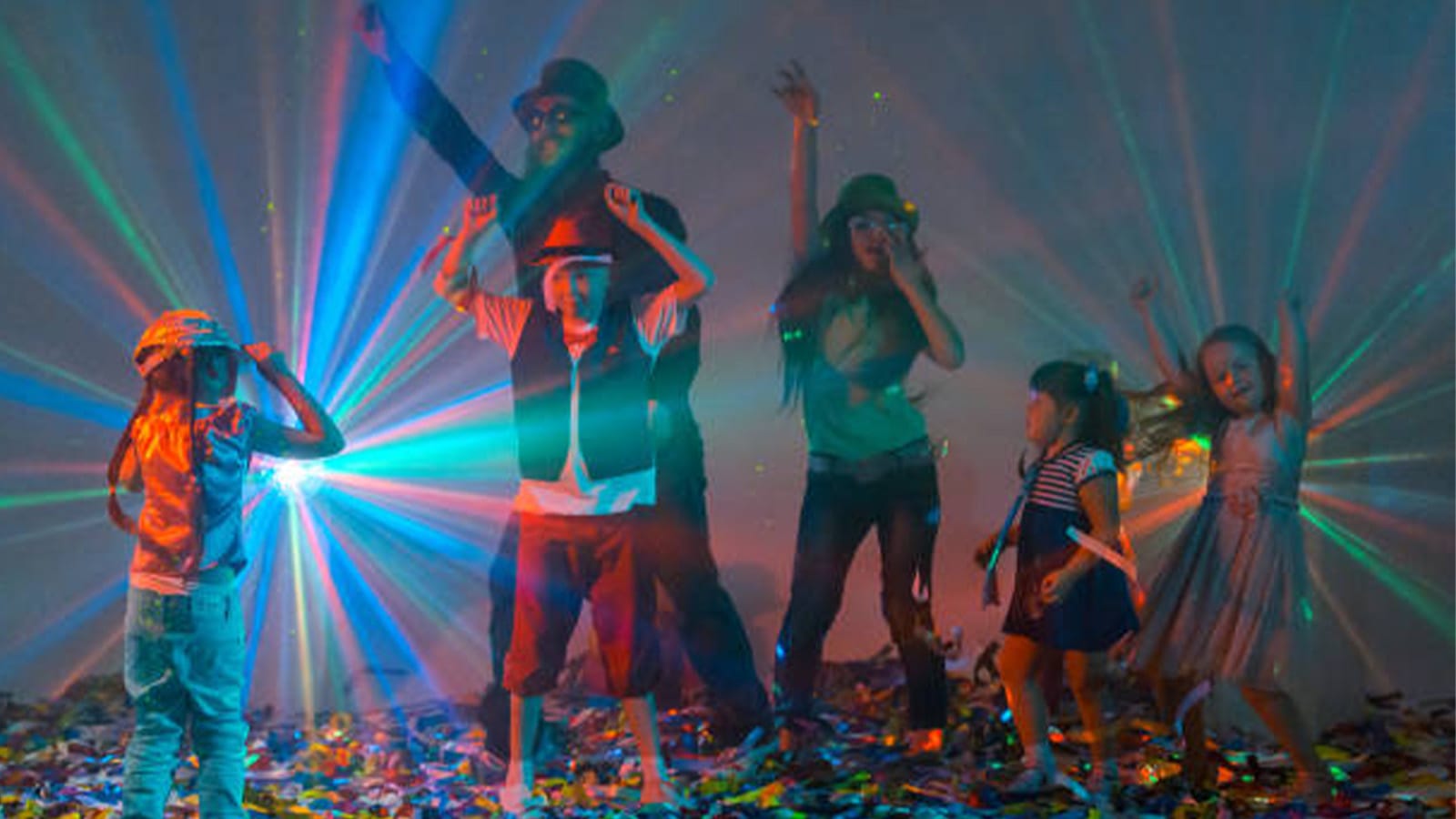 A group of children dance under disco lights