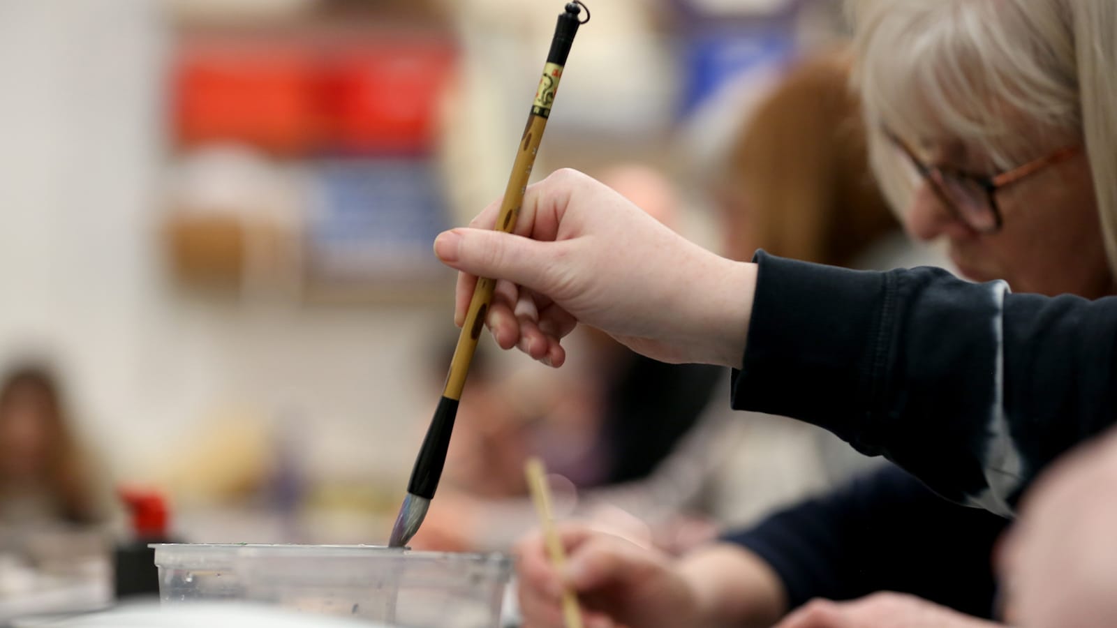 A hand holds up a paintbrush