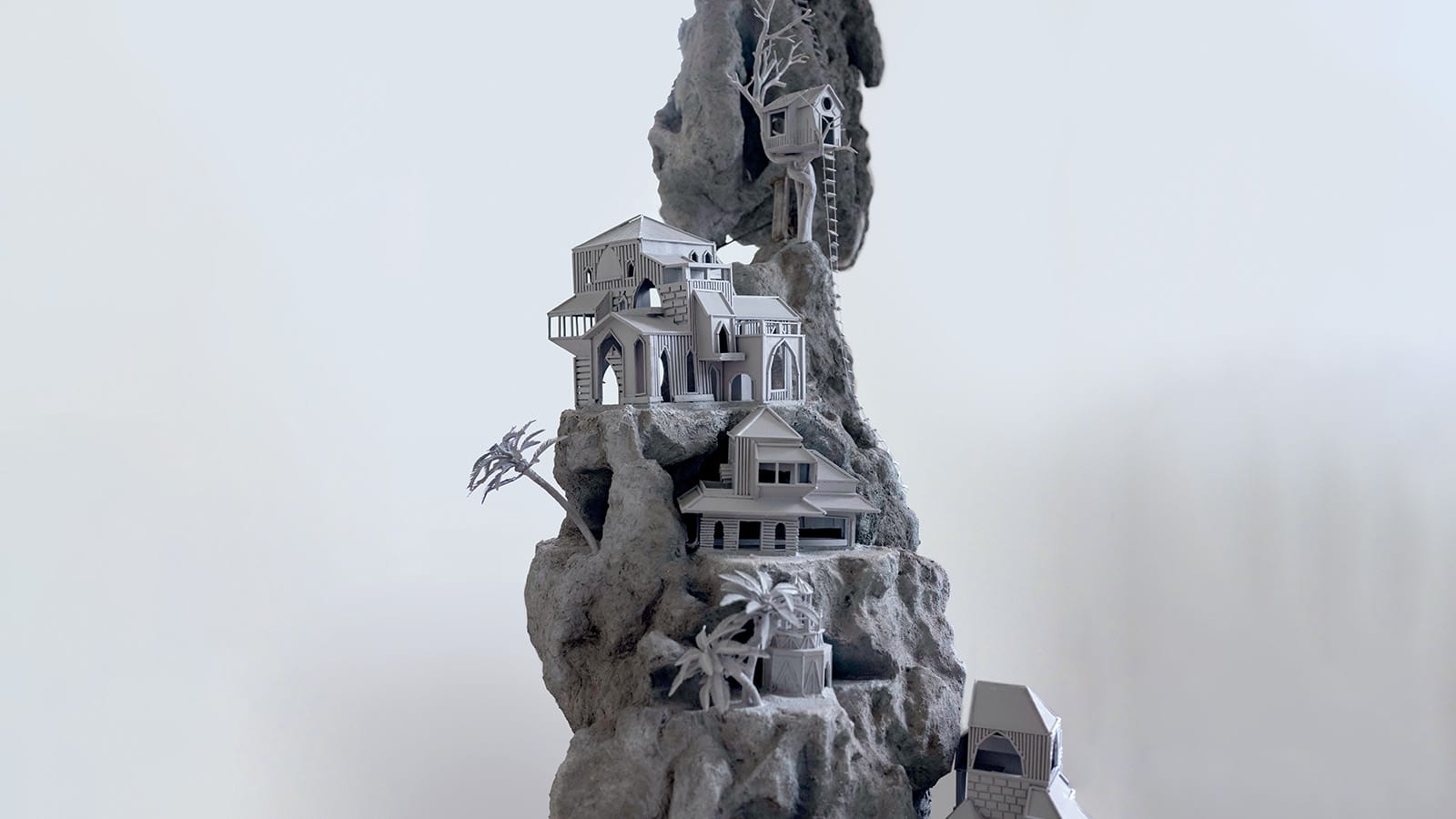 A grey sculpture of a landscape towering up to the sky