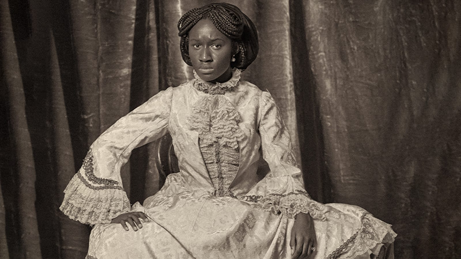 A black and white photo of a woman in victorian clothing and modern shoes