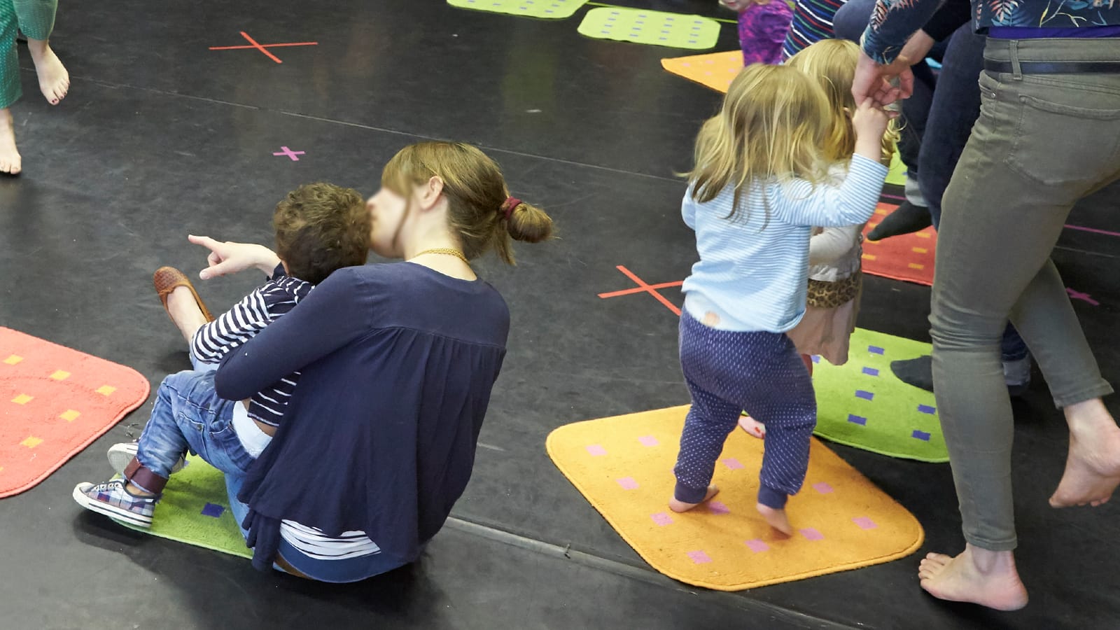 A mother and child walk around a studio in a dance circle