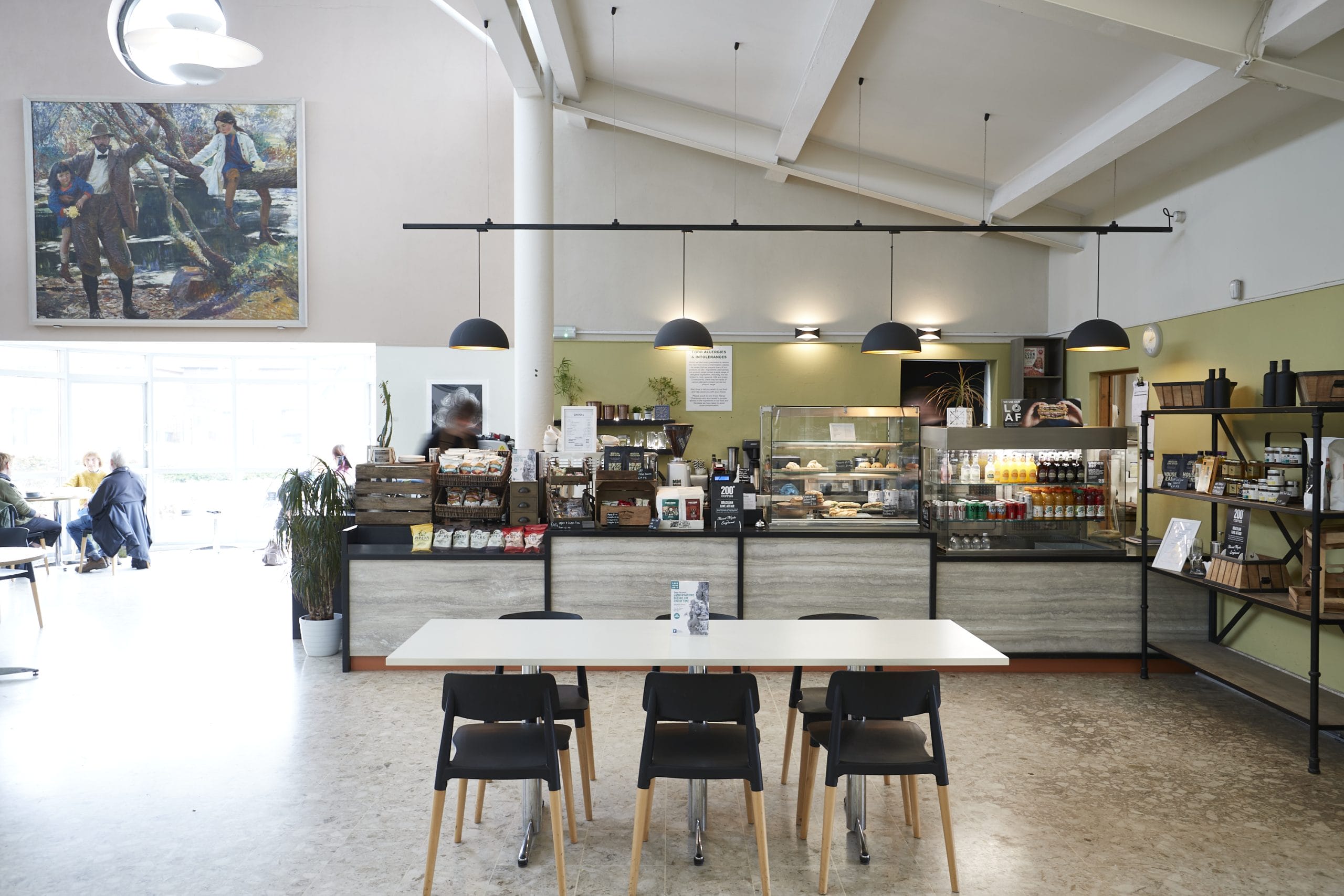 A bright and airy Gallery Café counter with a rectangular table and six chairs sat in front.