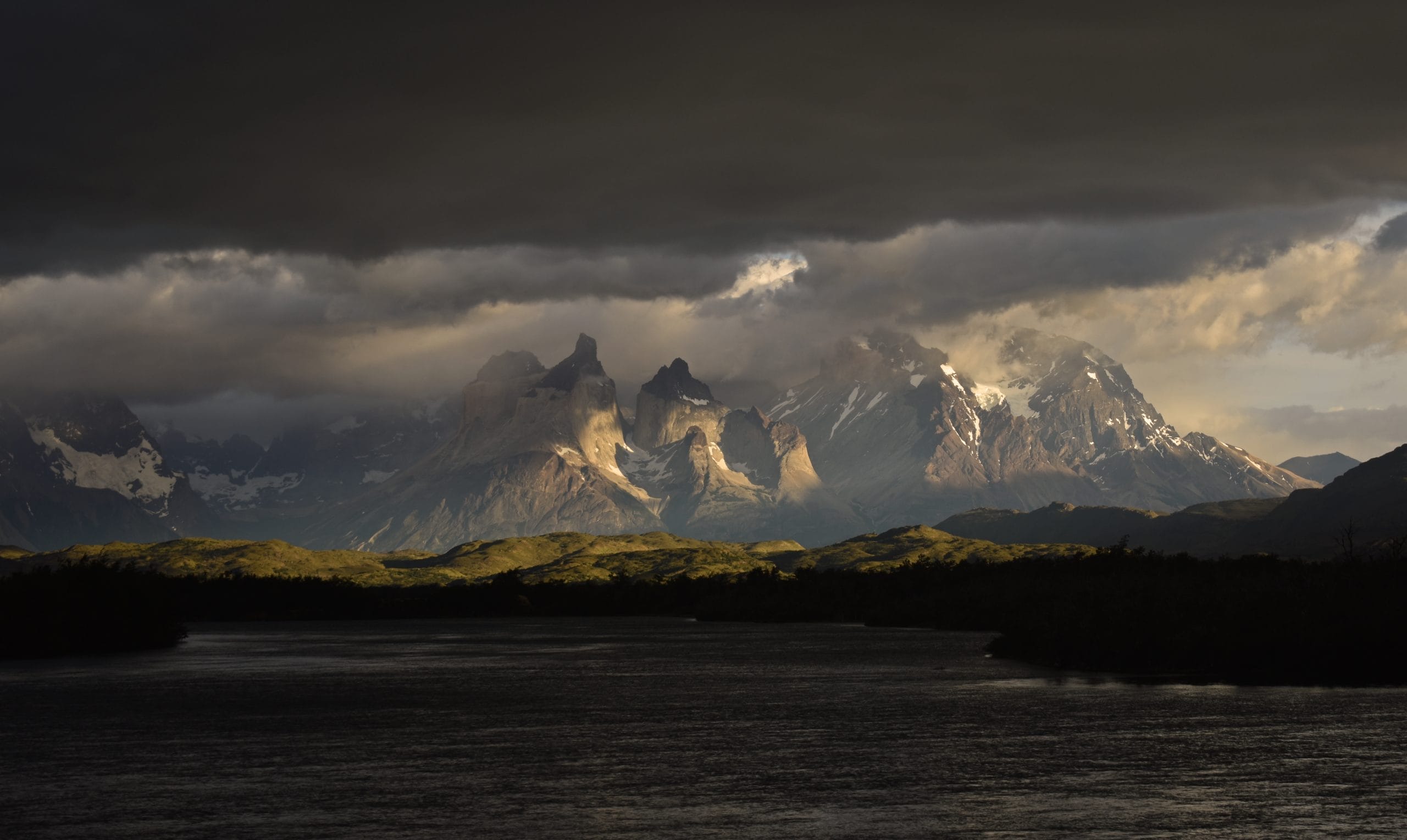 a photo of the mountains Torres del Paine in Chile, Patagonia with clouds sorrounding the snowy peaks
