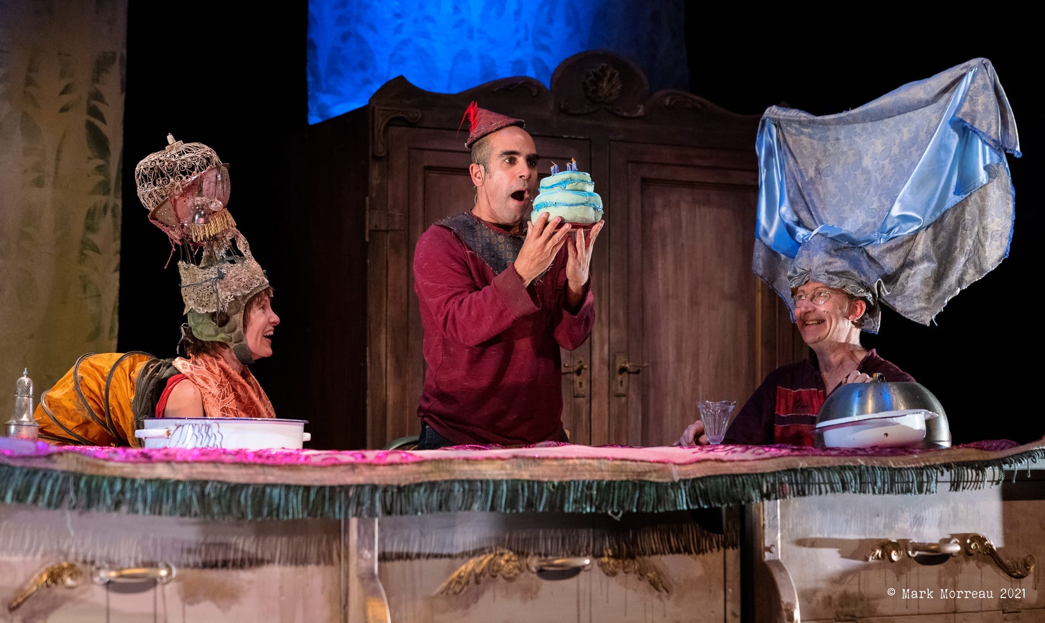 three people sitting around table on a stage