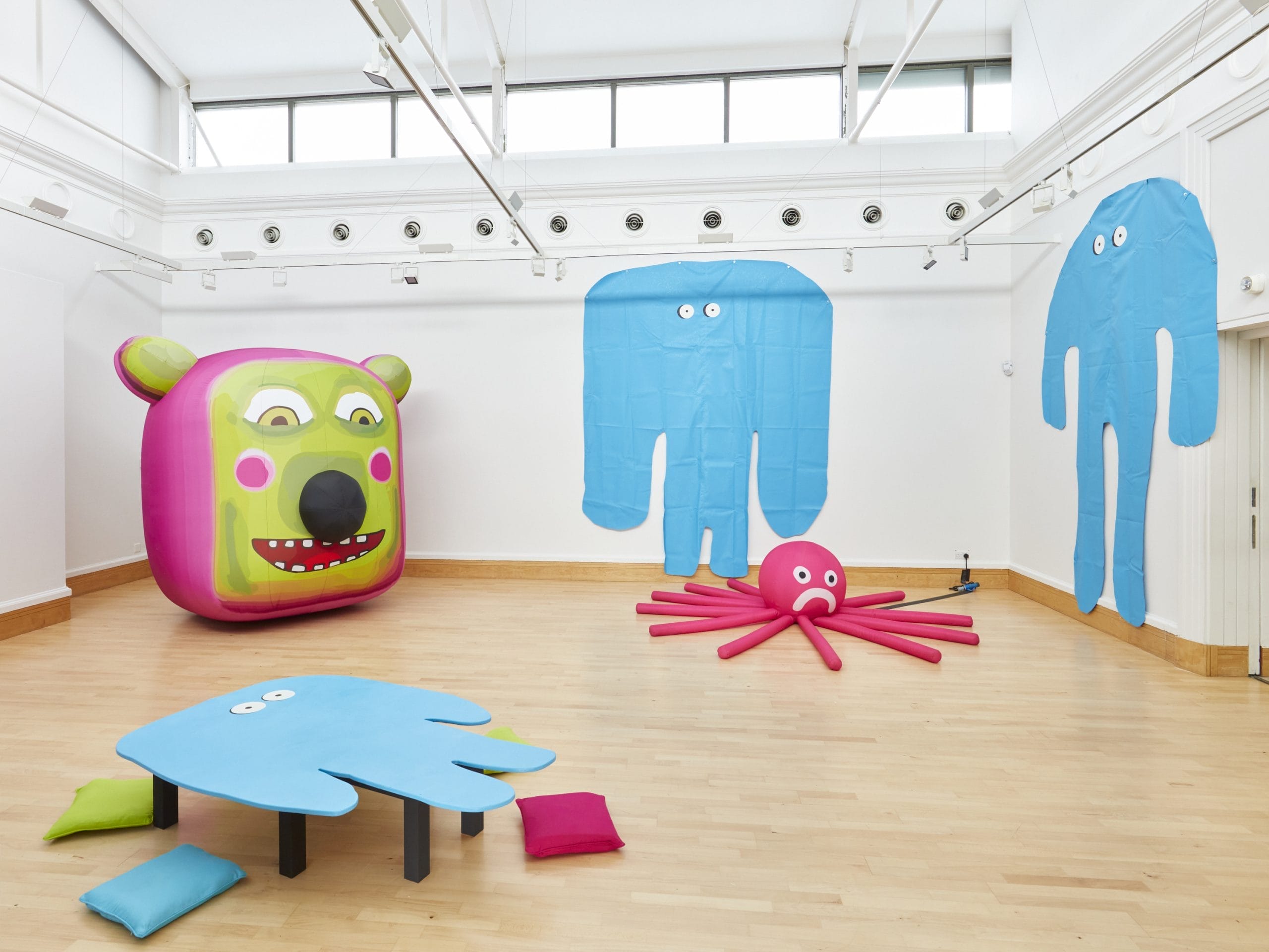 A white gallery space featuring a selection of brightly coloured monsters.