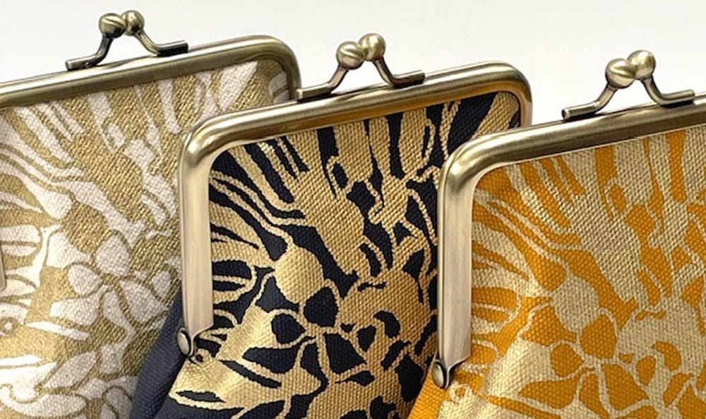 three gold coloured purses in a row with top fastenings