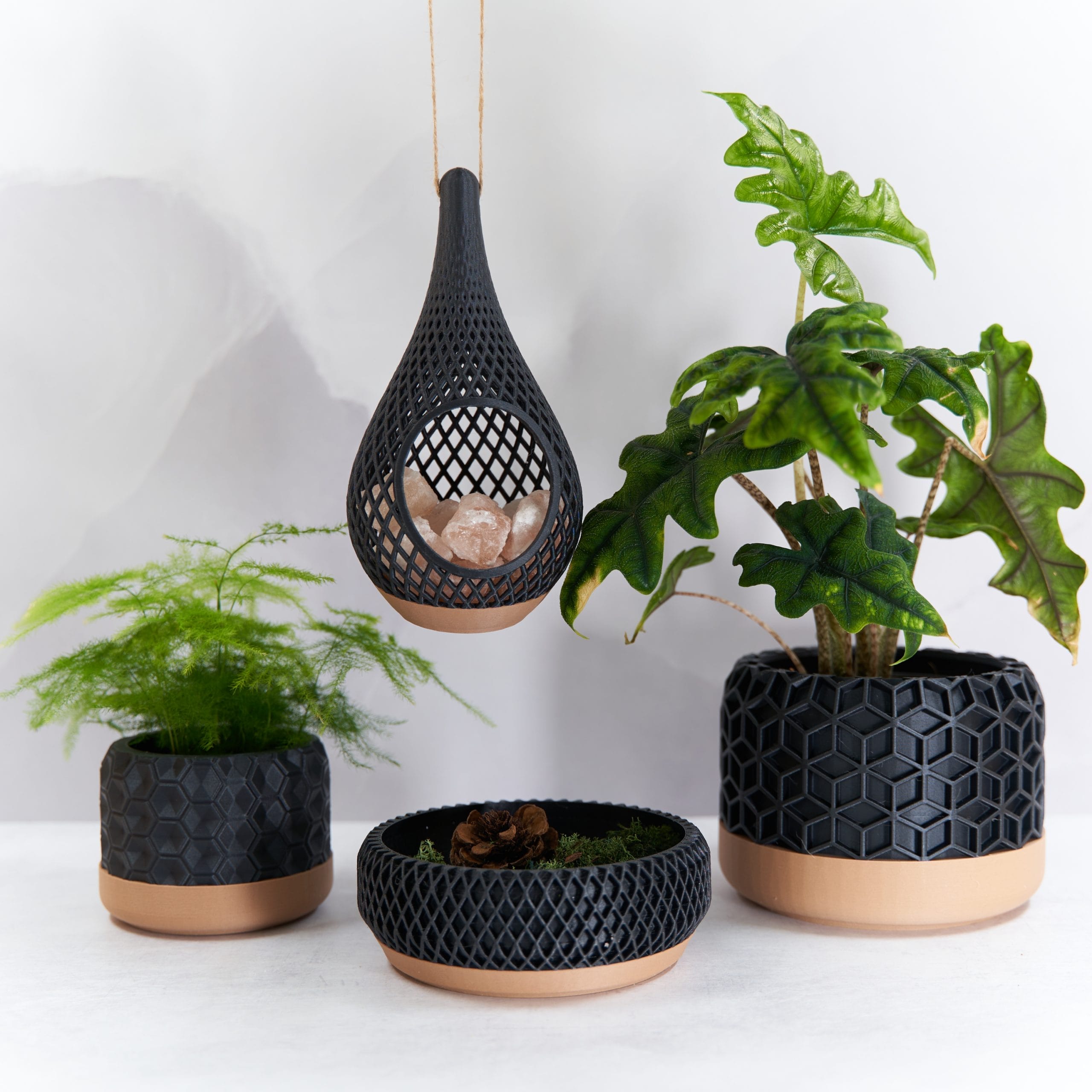 Four Black and wooden decorative pots. Two with plants in.