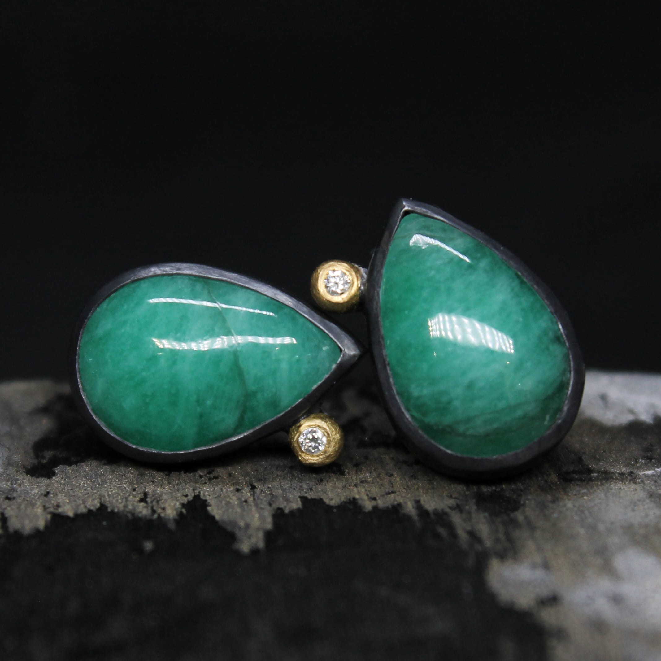 a pair of green stone tear drop shaped earrings