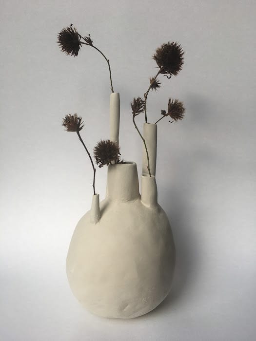 a cream coloured vase with multiple spouts