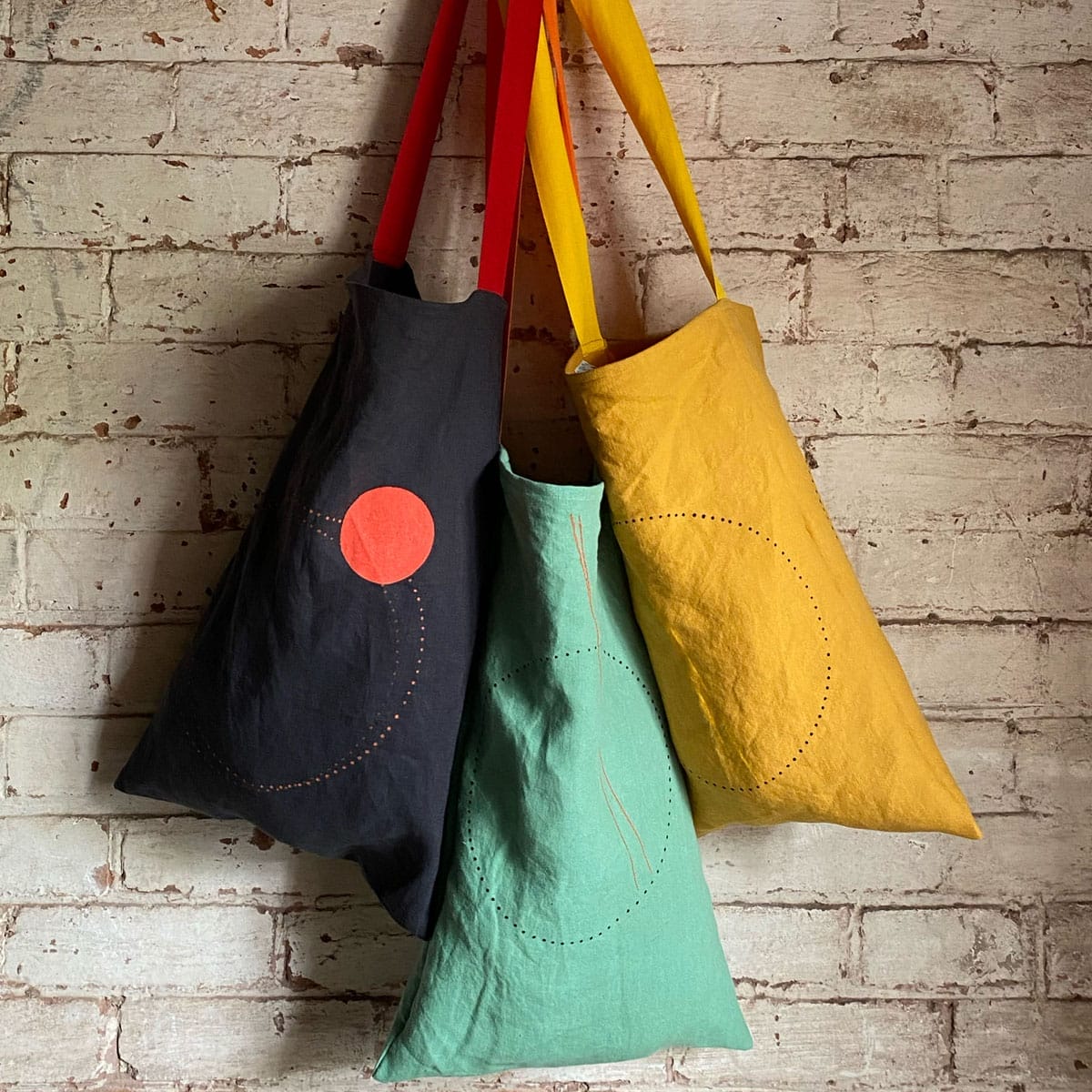 3 fabric bags hung up on a wall