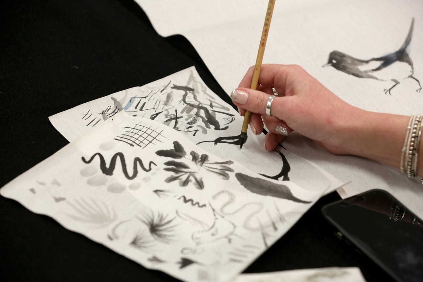 Close up photography of someone brush painting in blank ink