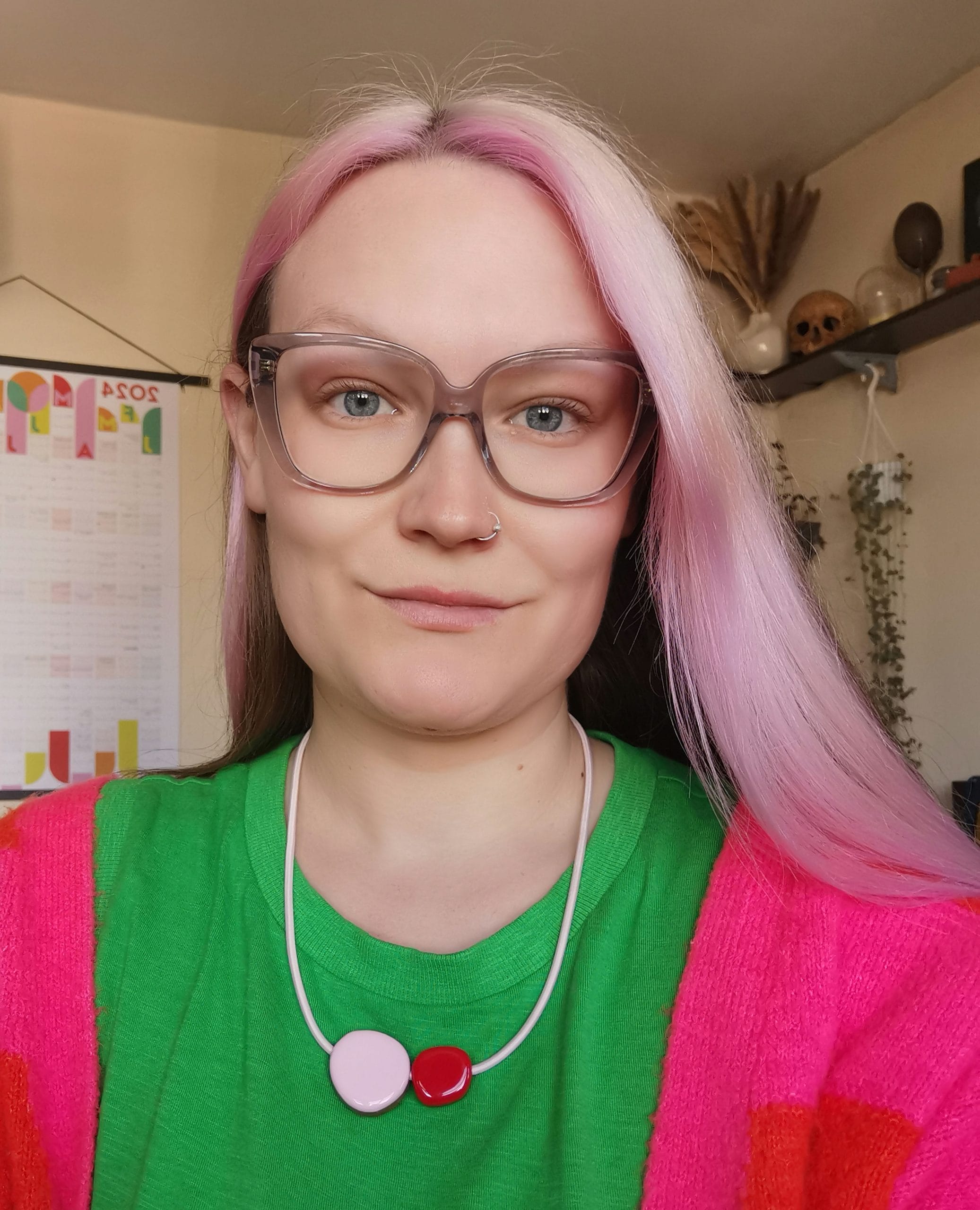 portrait of a lady with pink hair wearing a necklace and glasses