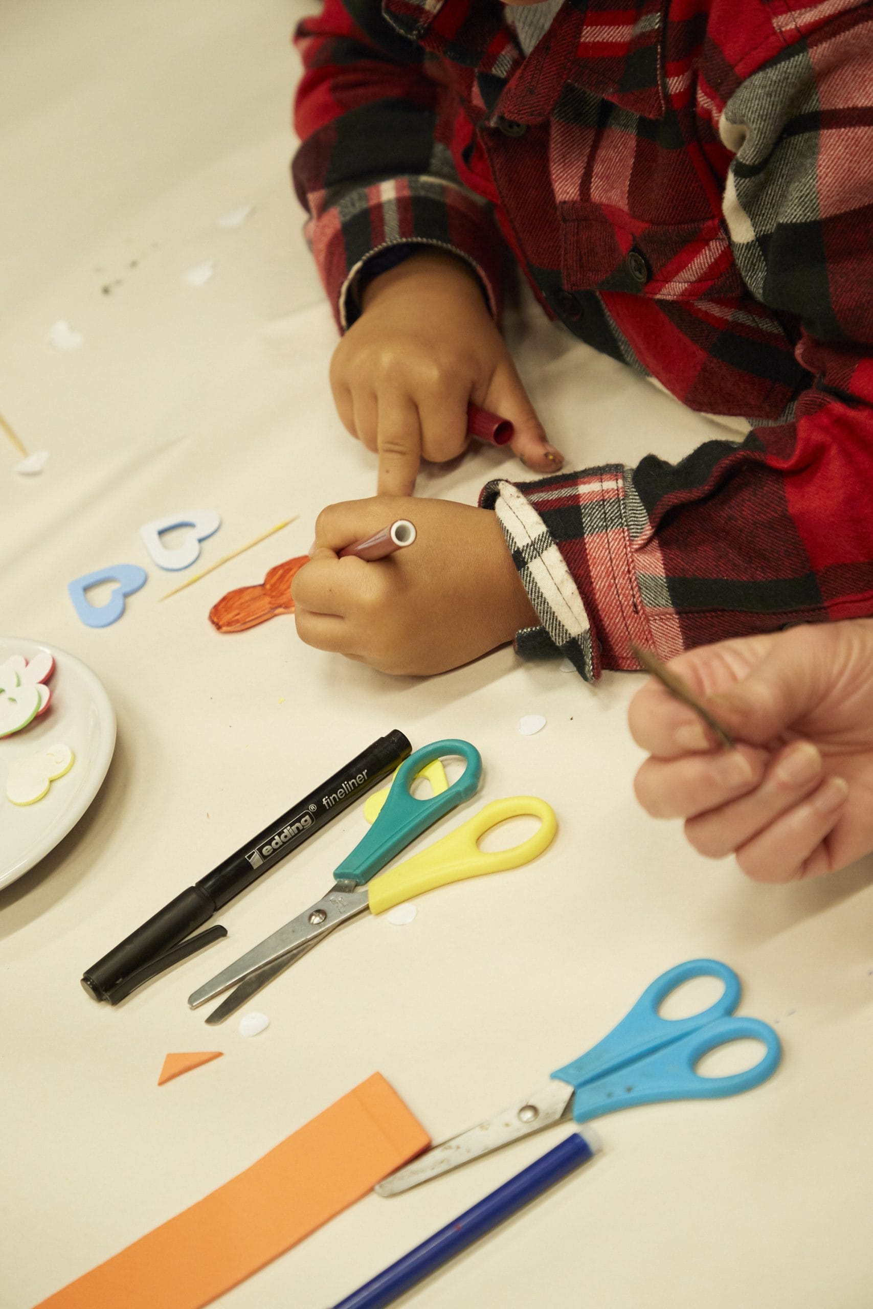 A small child surrounded by craft materials.