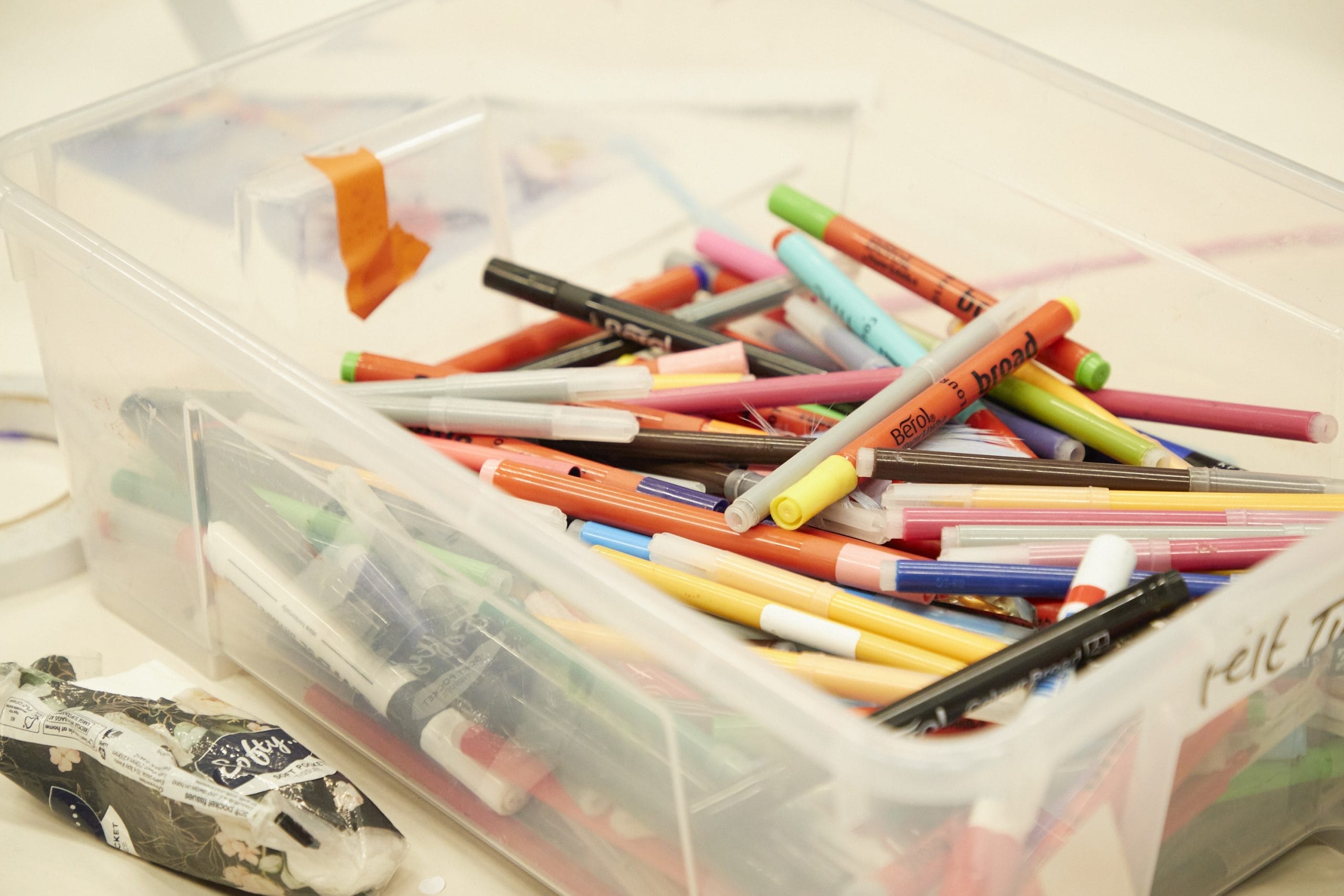 A pot of colouring pens sat on a table