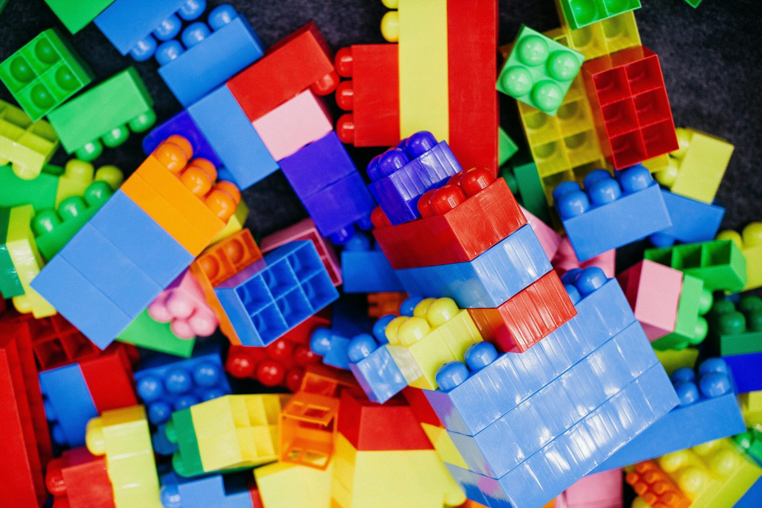 A pile of brightly coloured plastic building blocks.