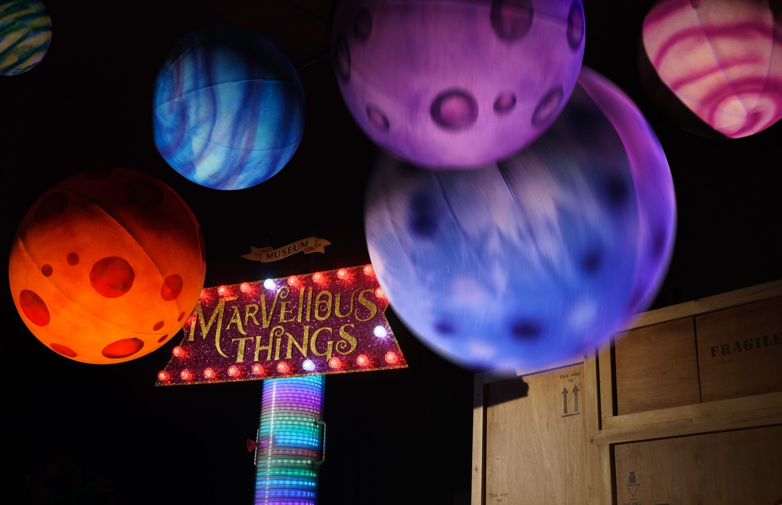 A photo of colourful planet balloons above the set of The Museum of Marvellous Things