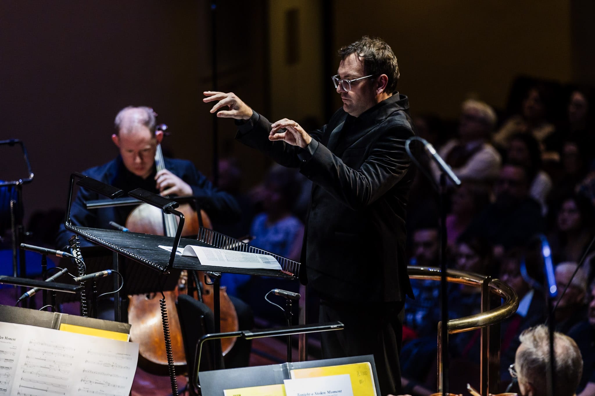 a conductor with his hands held high while in concert