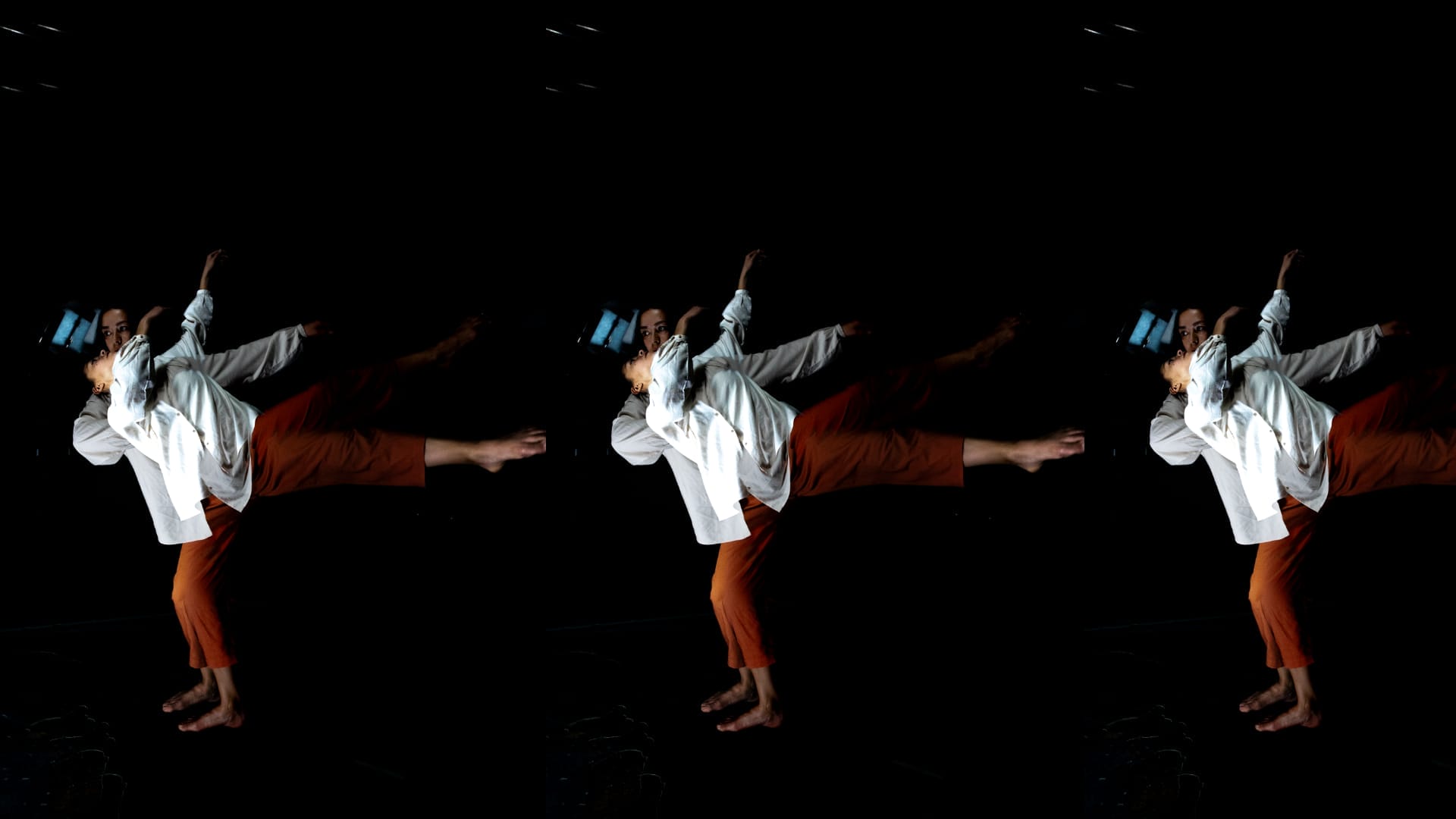 Three dancers, wearing white shirts and VR headsets.
