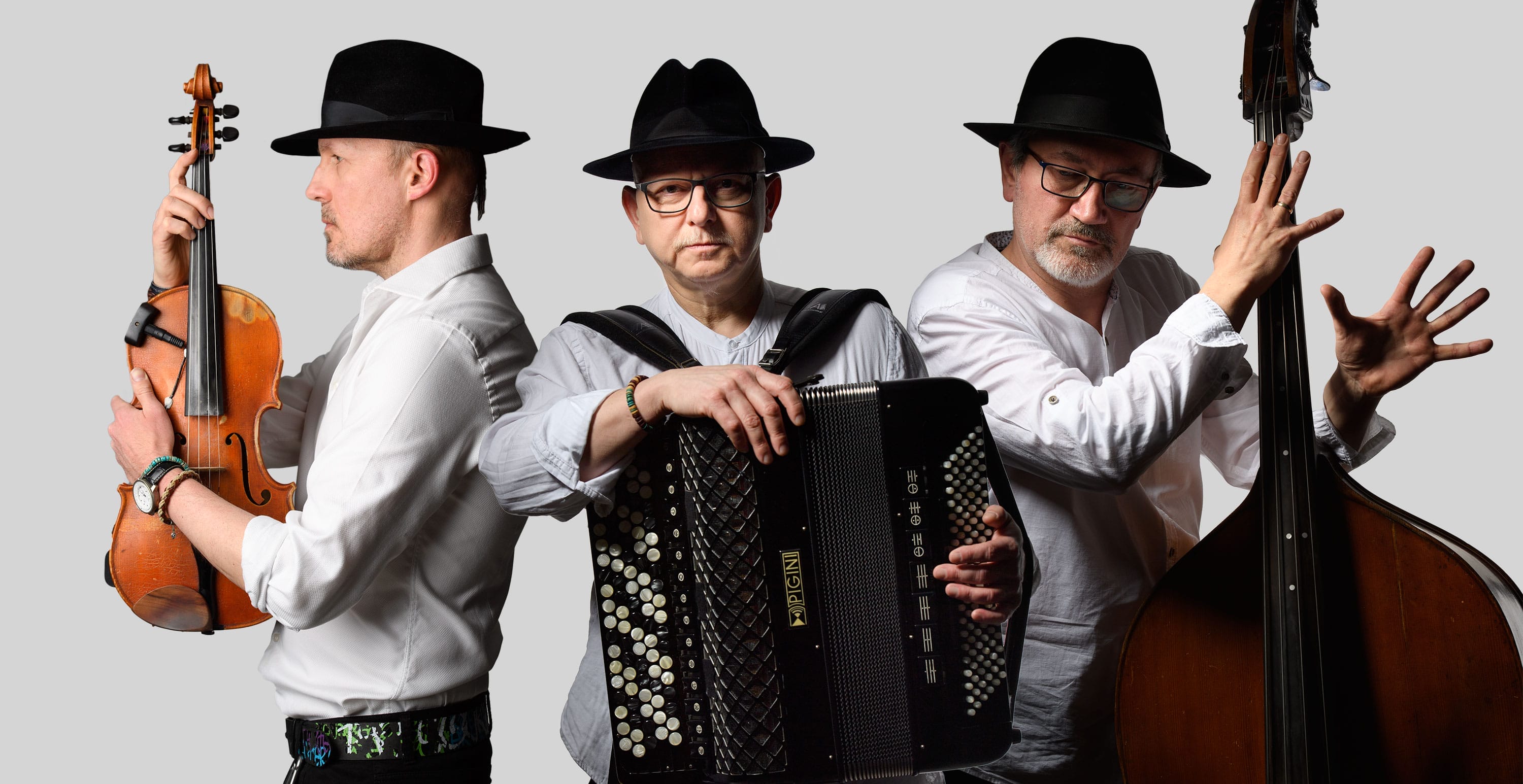a picture of three musicians in white shirts and black hats holding their instruments