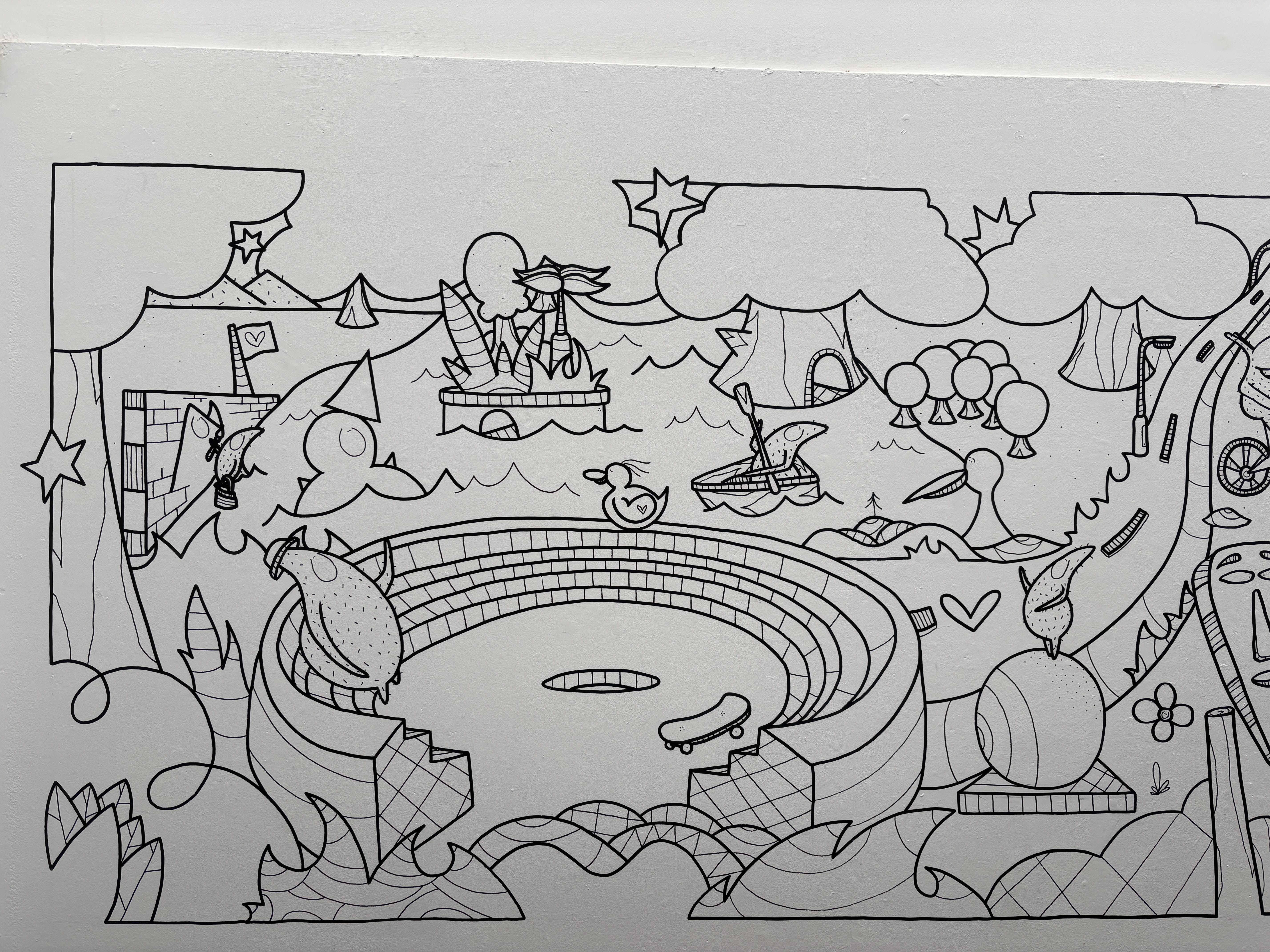 A corner of a room, where white walls have been illustrated with characters and symbols, in just black outlines