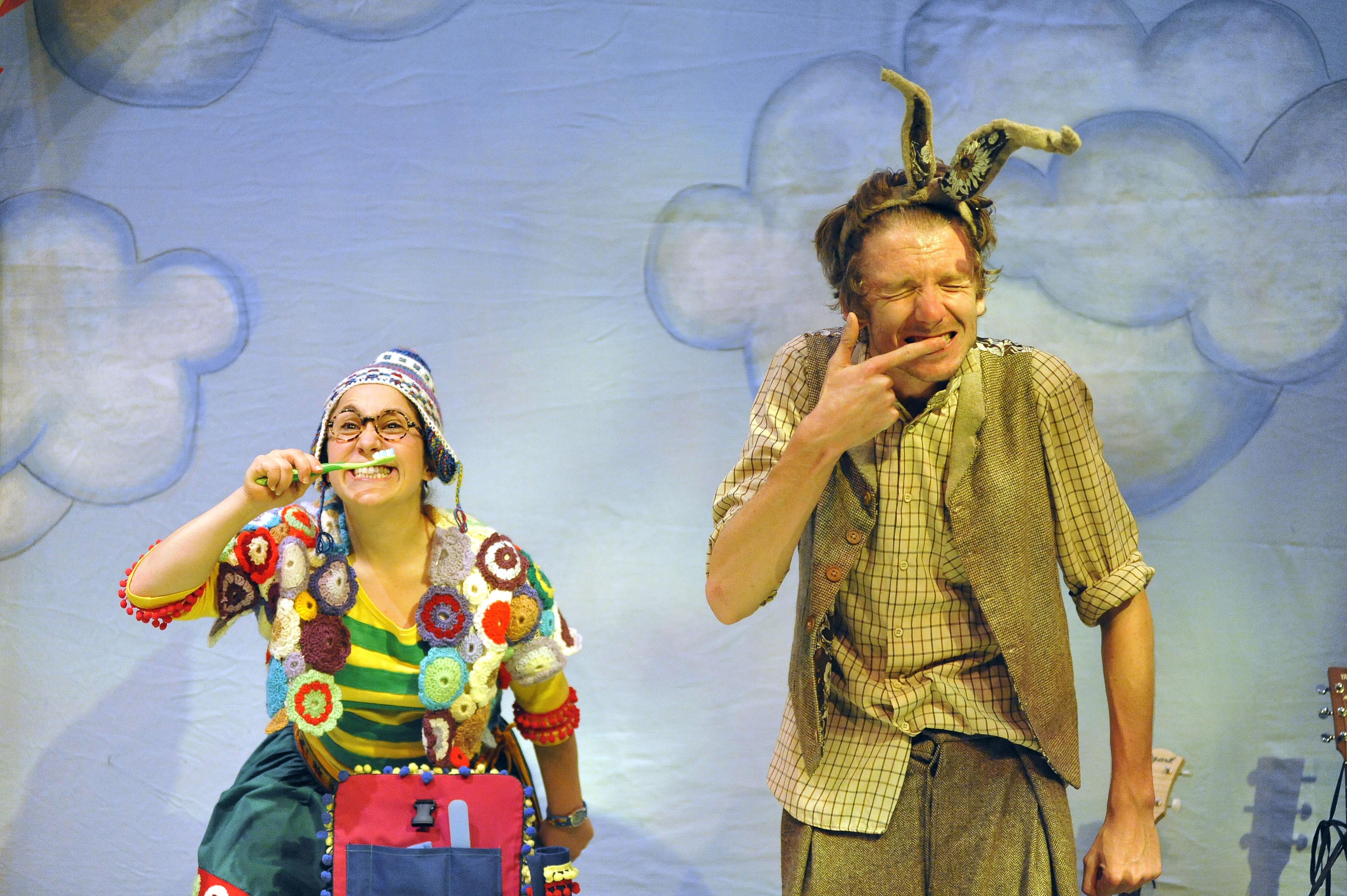 Two actors dressed as a hare and tortoise are washing their teeth
