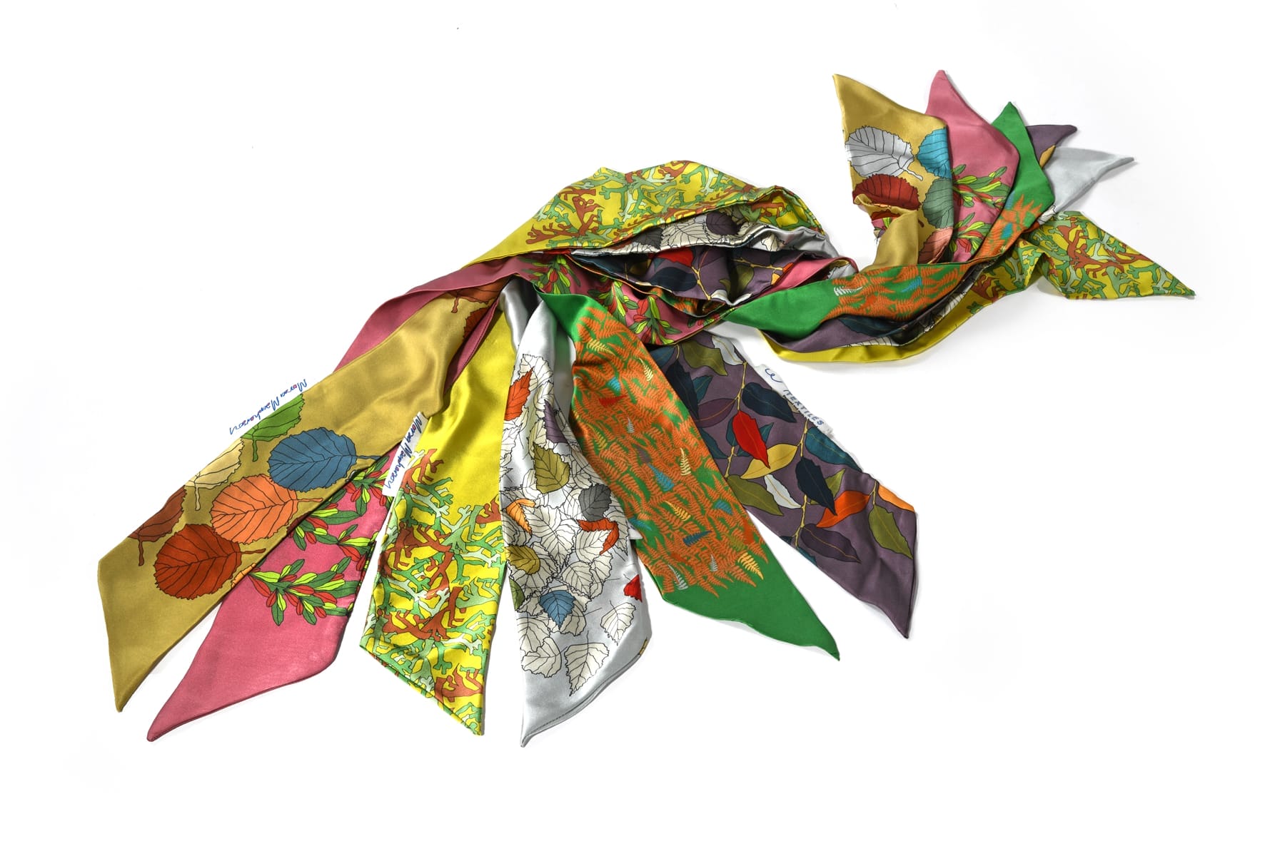 A collection of silk scarves on a white background.