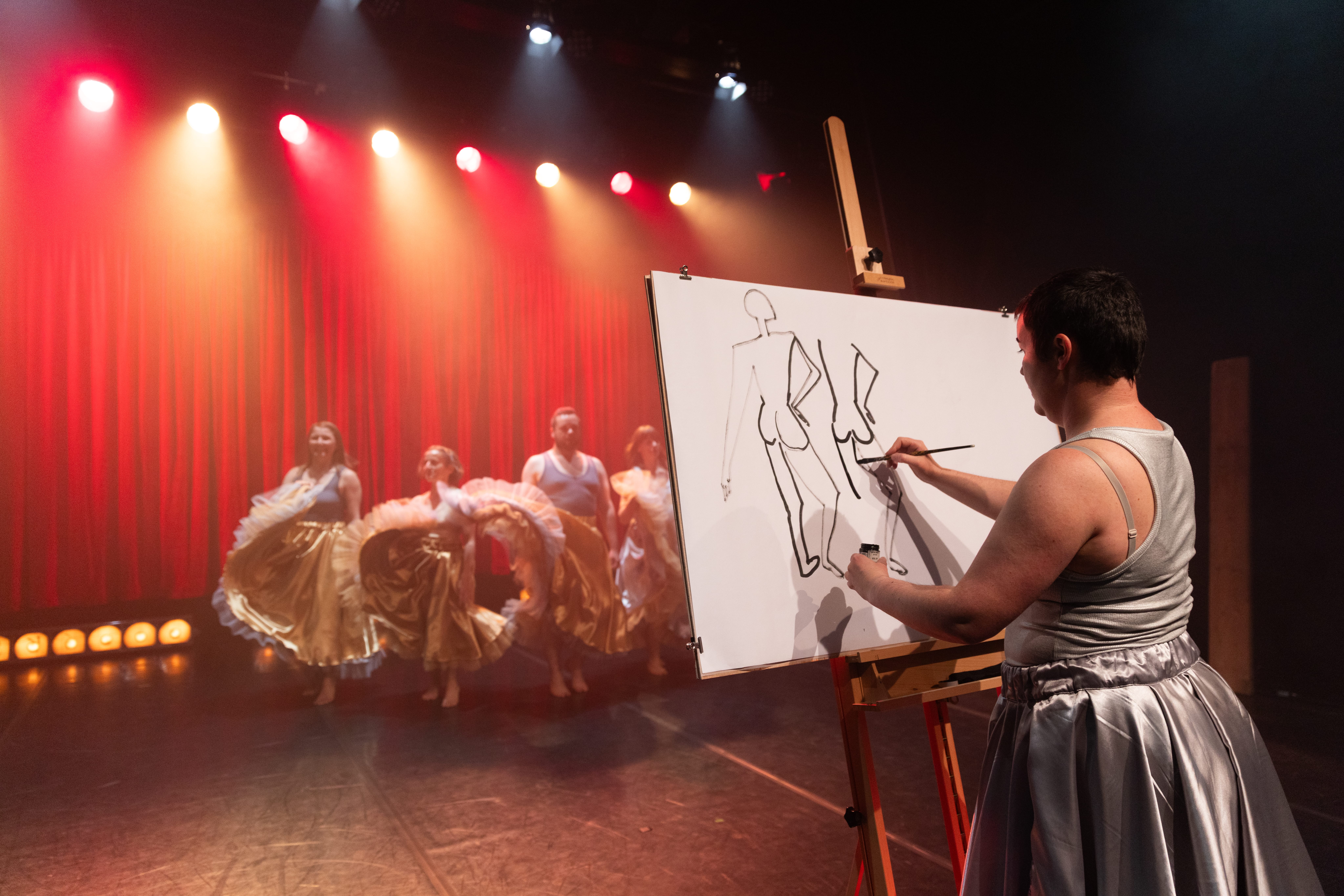 A woman is painting the silhuettes of a group of dancing people