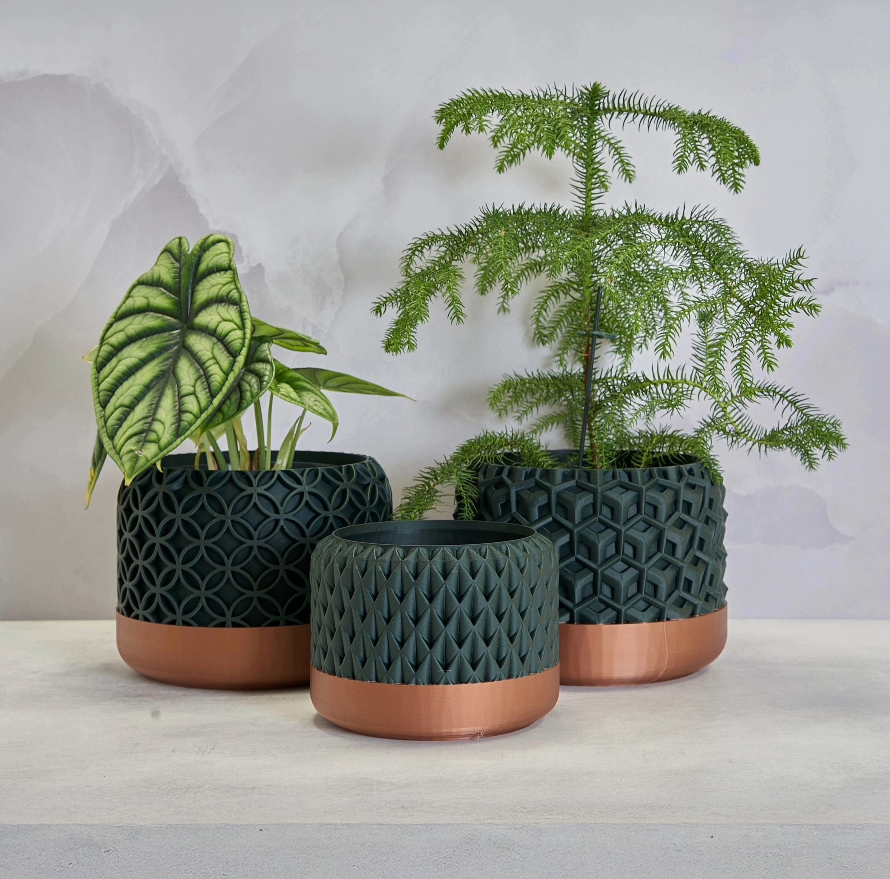 Highly textural plant pots, in dark green and copper.