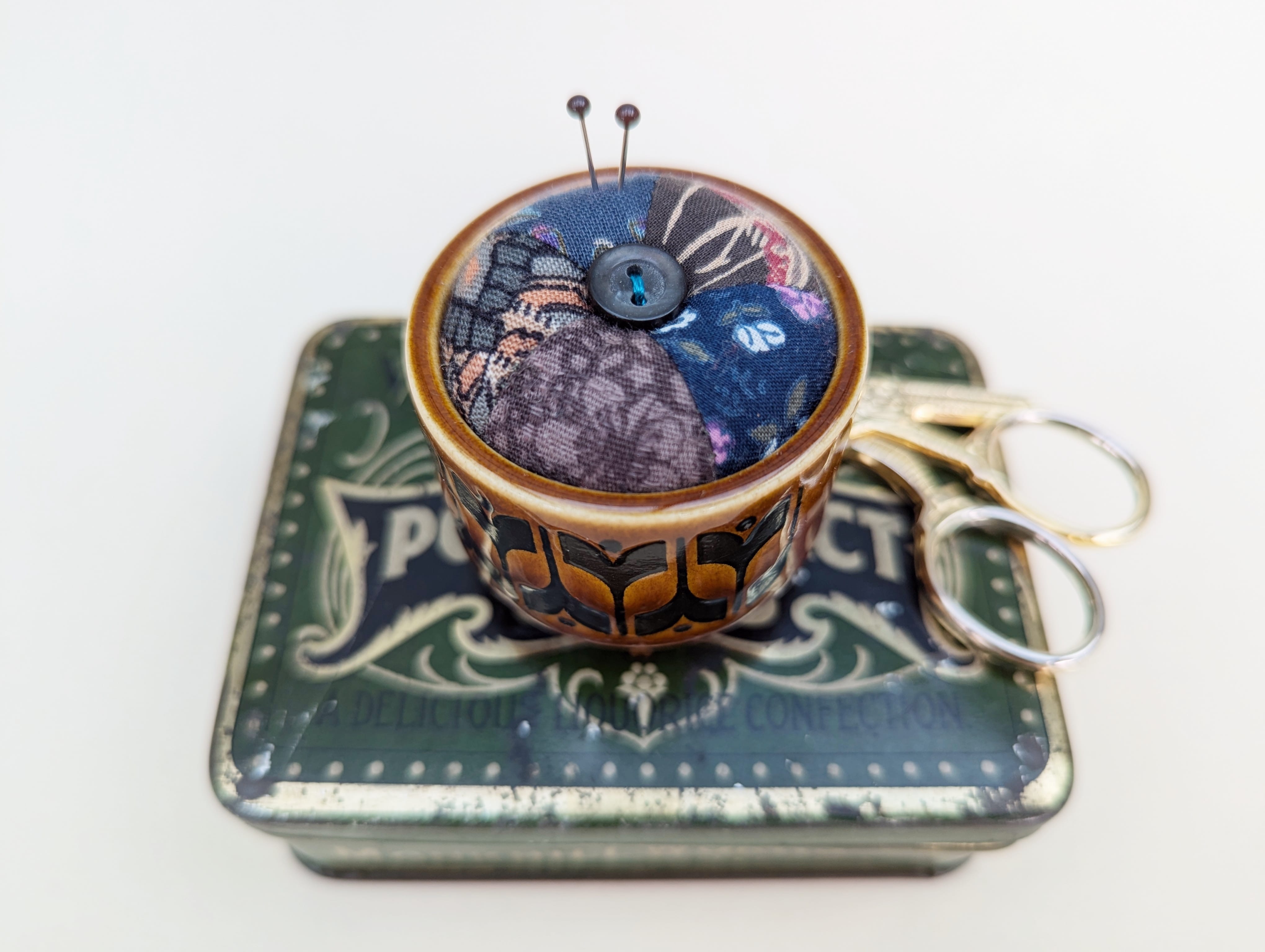 Pincushion with different dark purple, blue coloured fabric sexn together