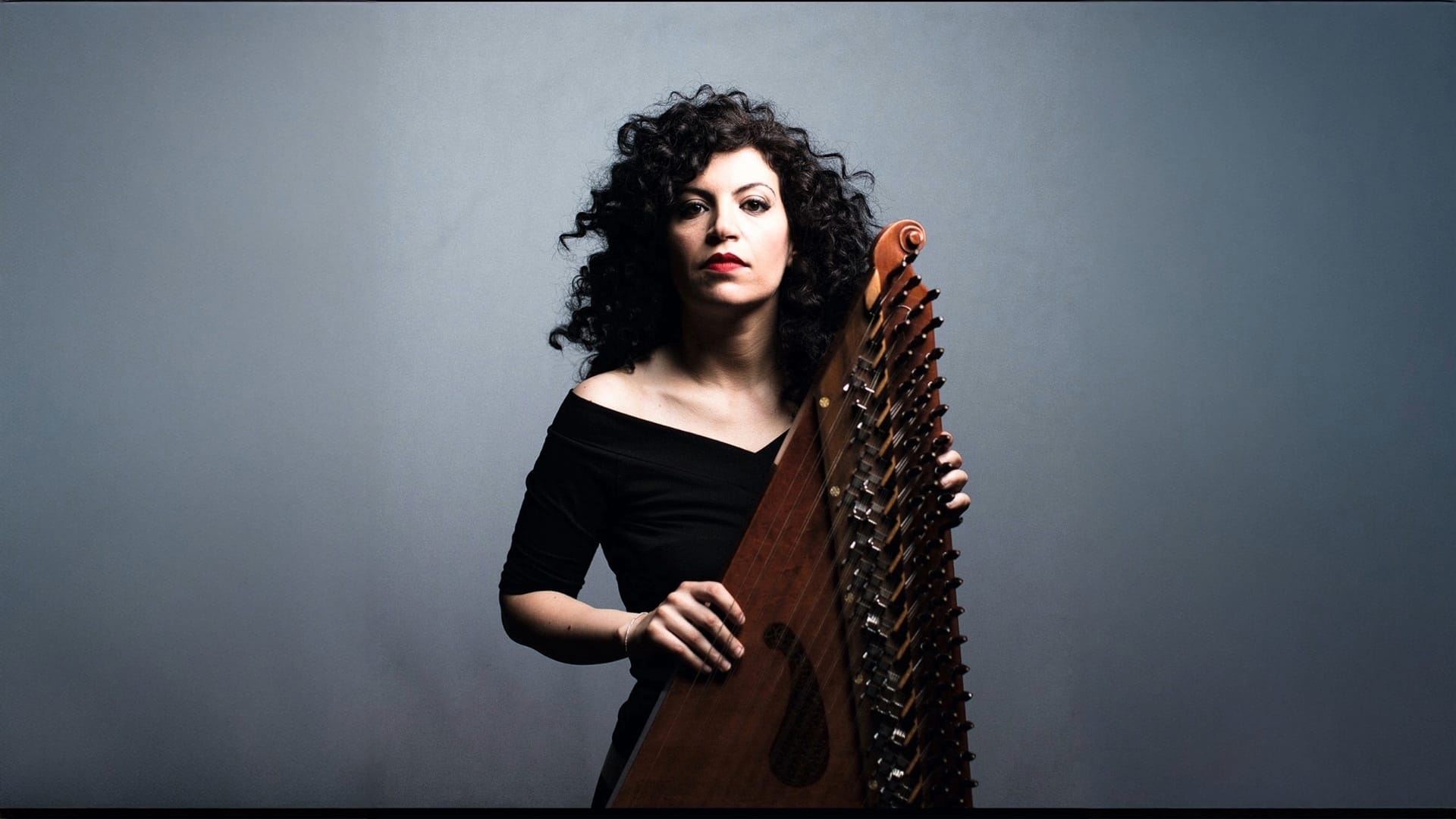 Maya Youssef looks boldly at the camera holding her zither