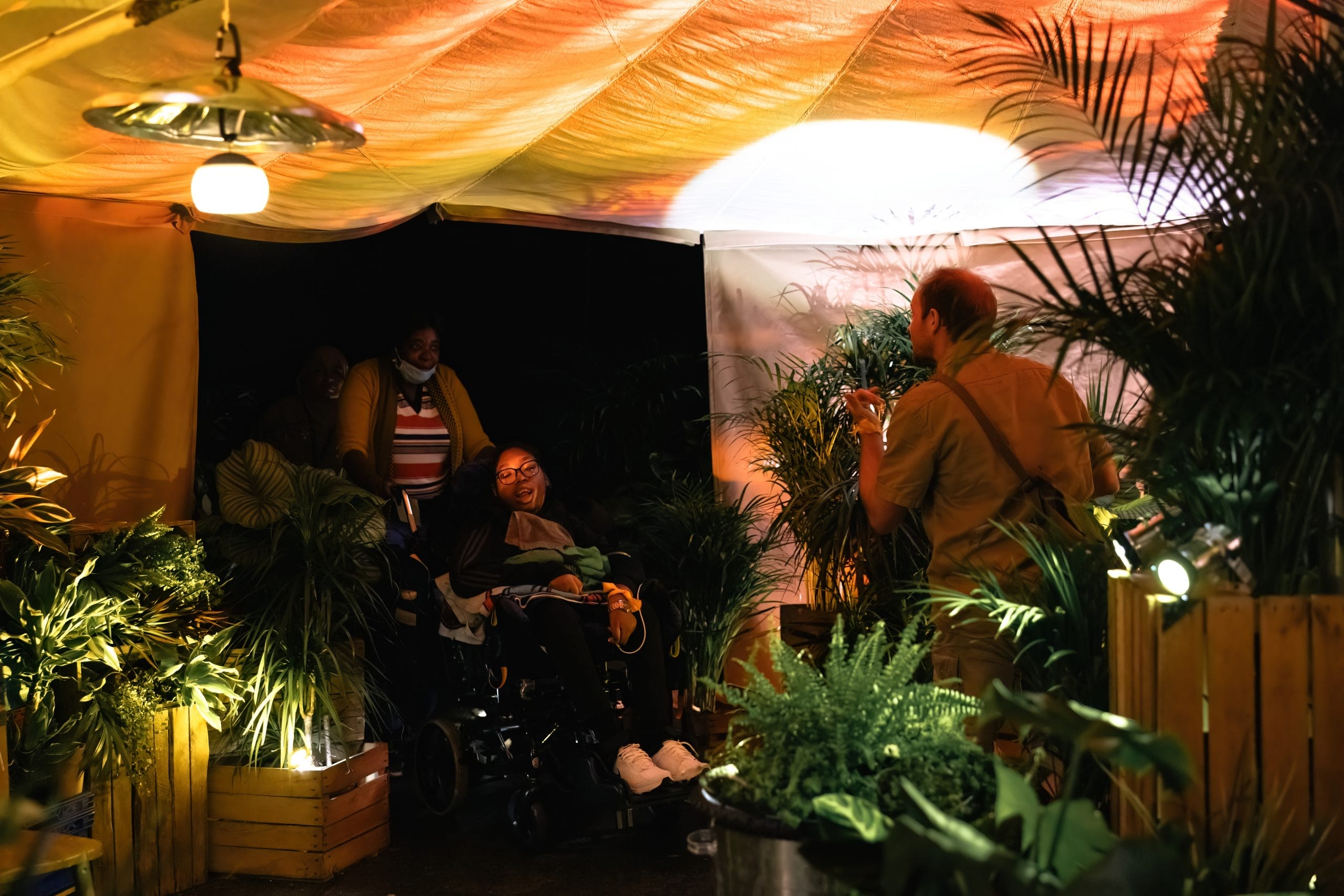 A member of the Oily Cart team interacts with a person in a wheelchair.