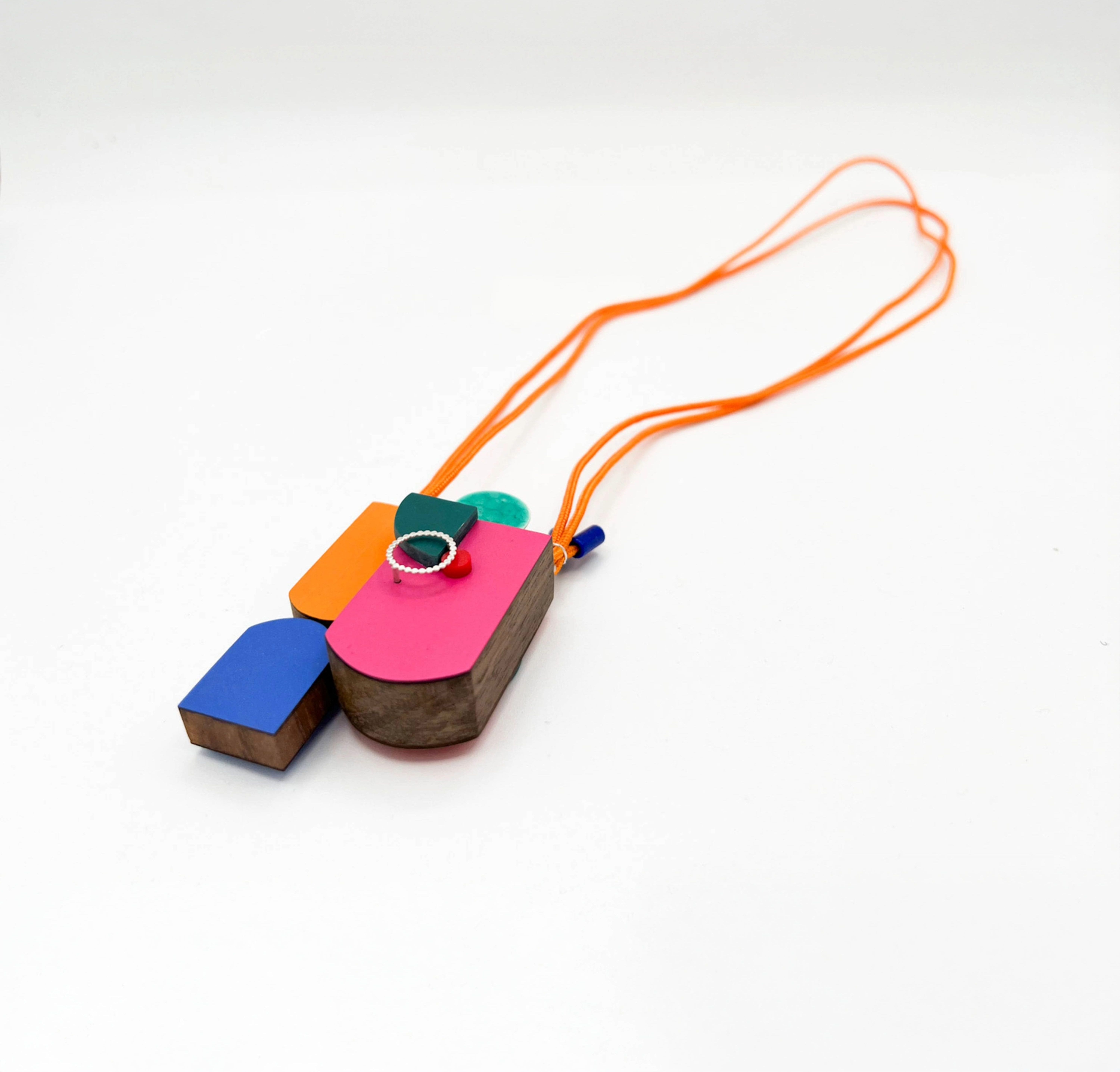 Necklace with a large vibrantly coloured pendant, with pink, orange, blue and green.