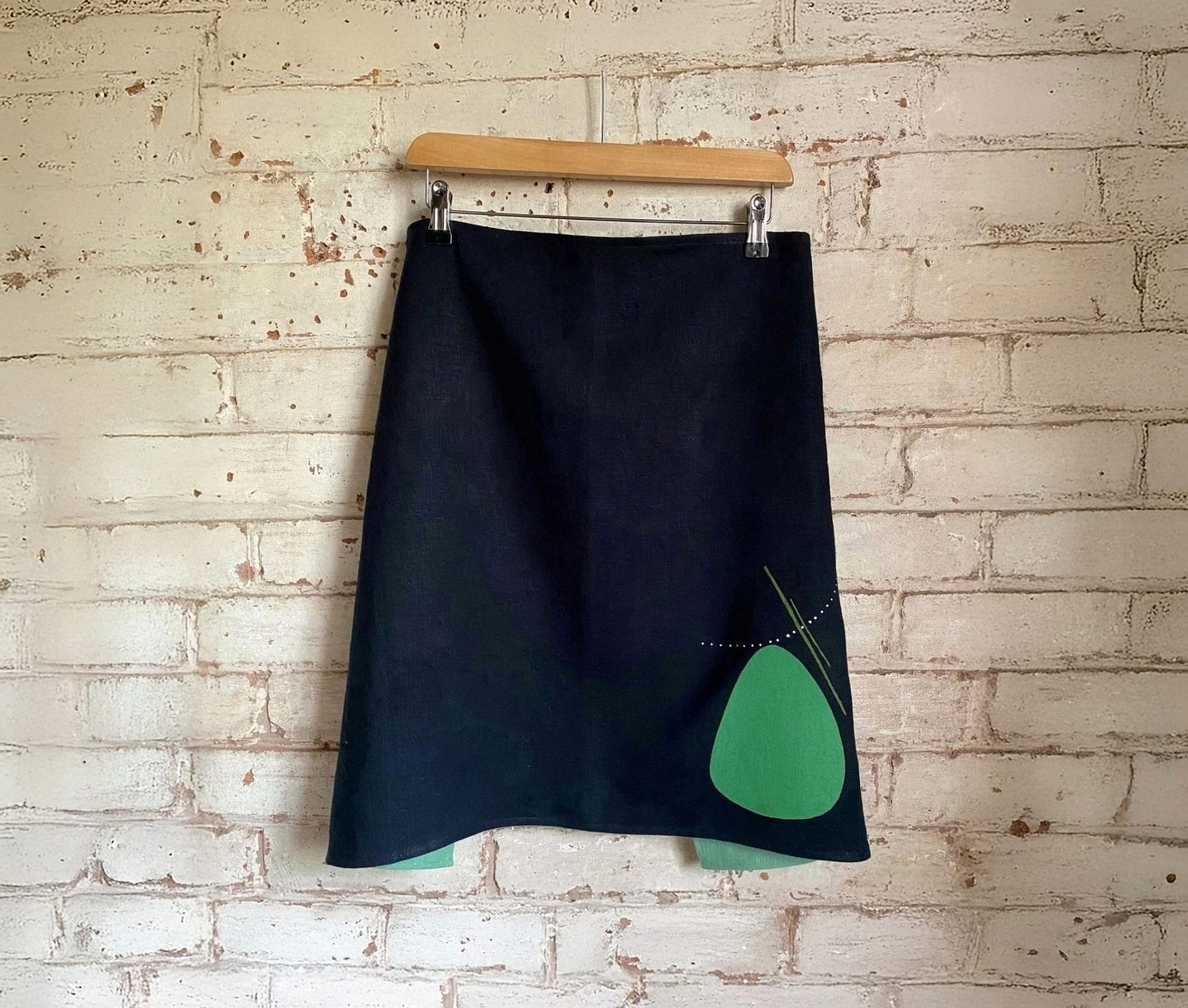 A black skirt with a cut out design, allowing an apple green shape to pop through.