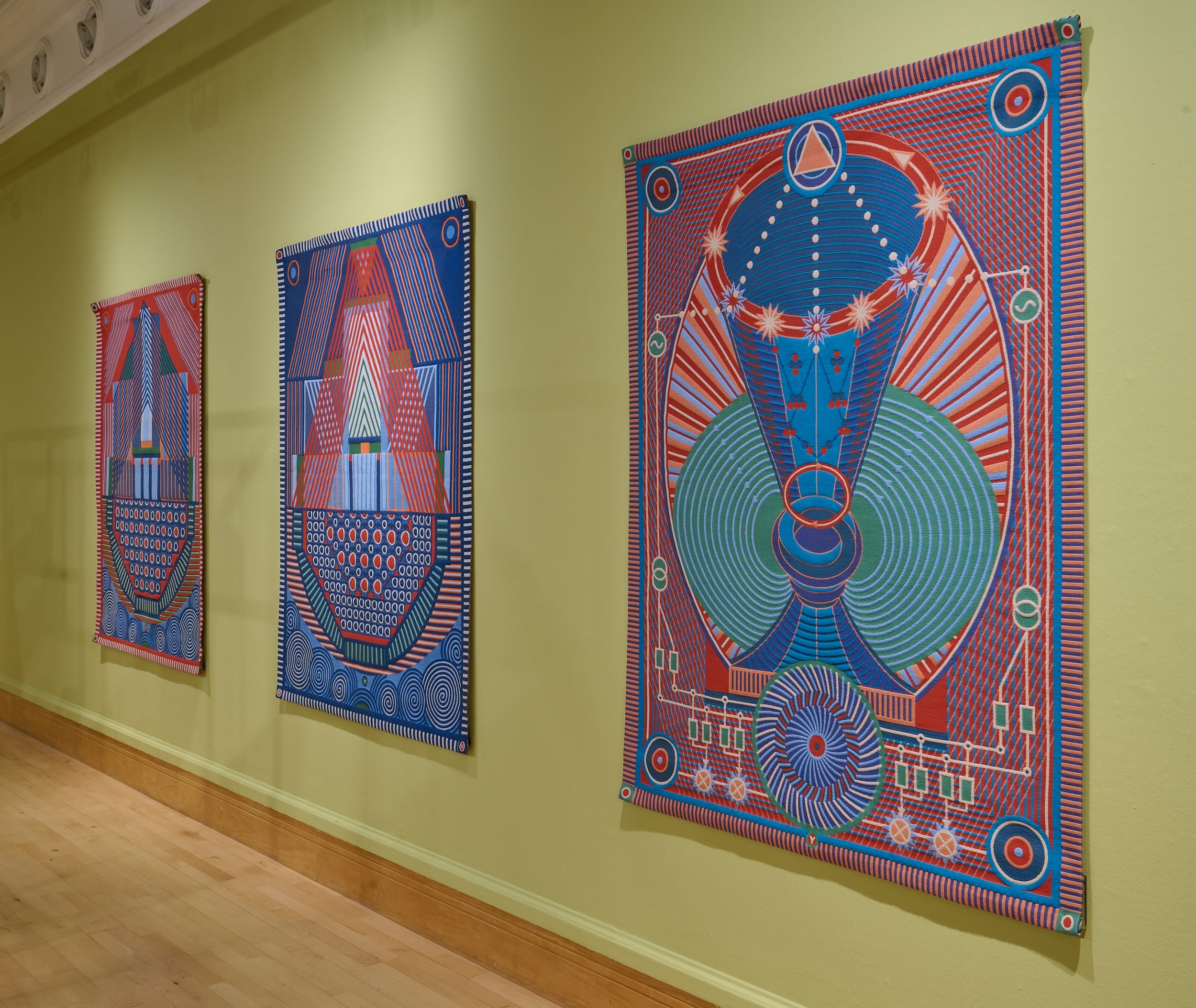 The photograph is taken from a slant depicting the 3 tapestries by Popova in the exhibition