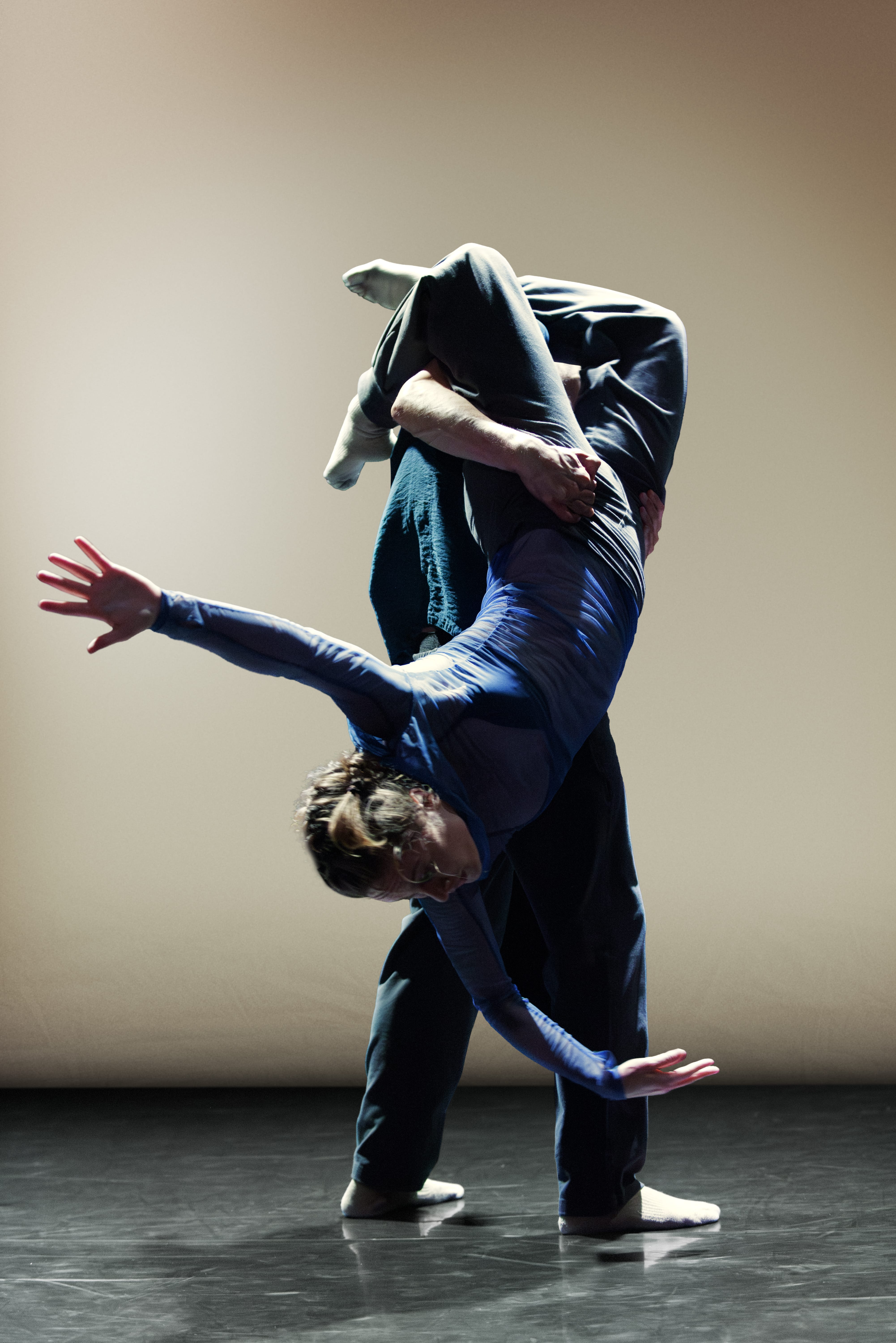 Two dancers perform, one supporting the other whilst upside down.