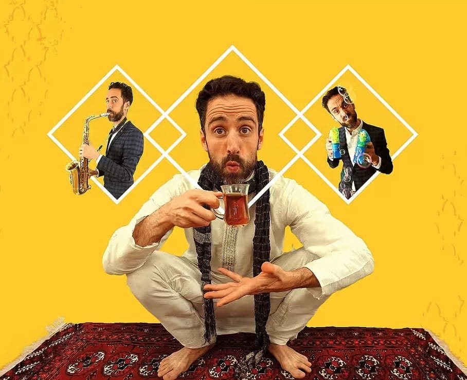 A man squats on a rug, drinking Persian tea.