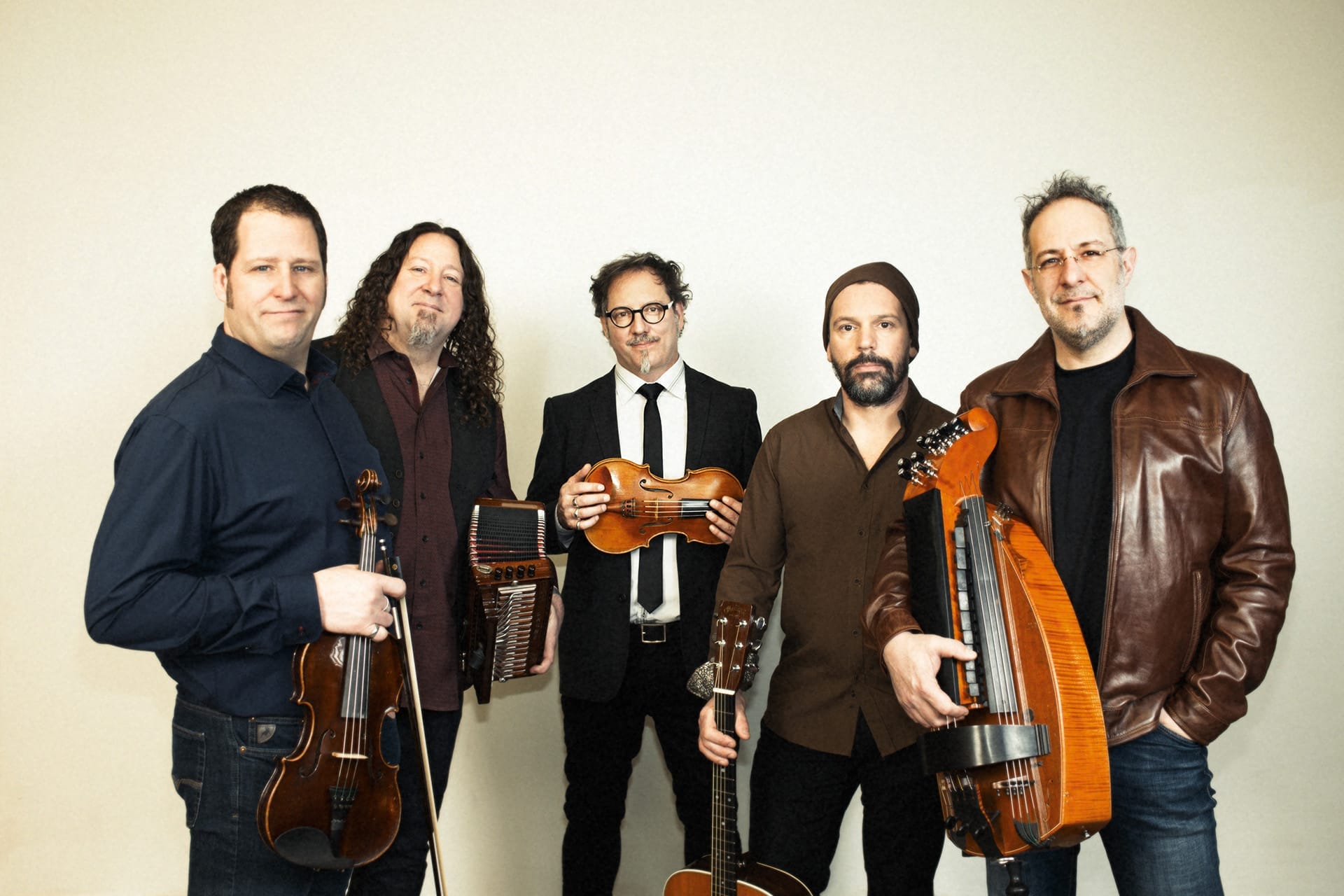 Five musicians stand with their instruments.